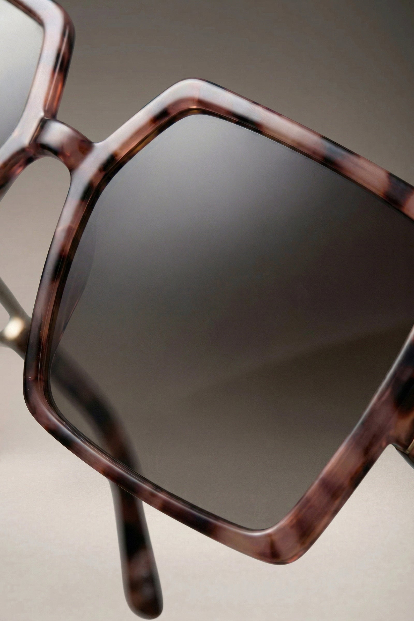 Close-up of oversized square sunglasses lens and tortoiseshell frame