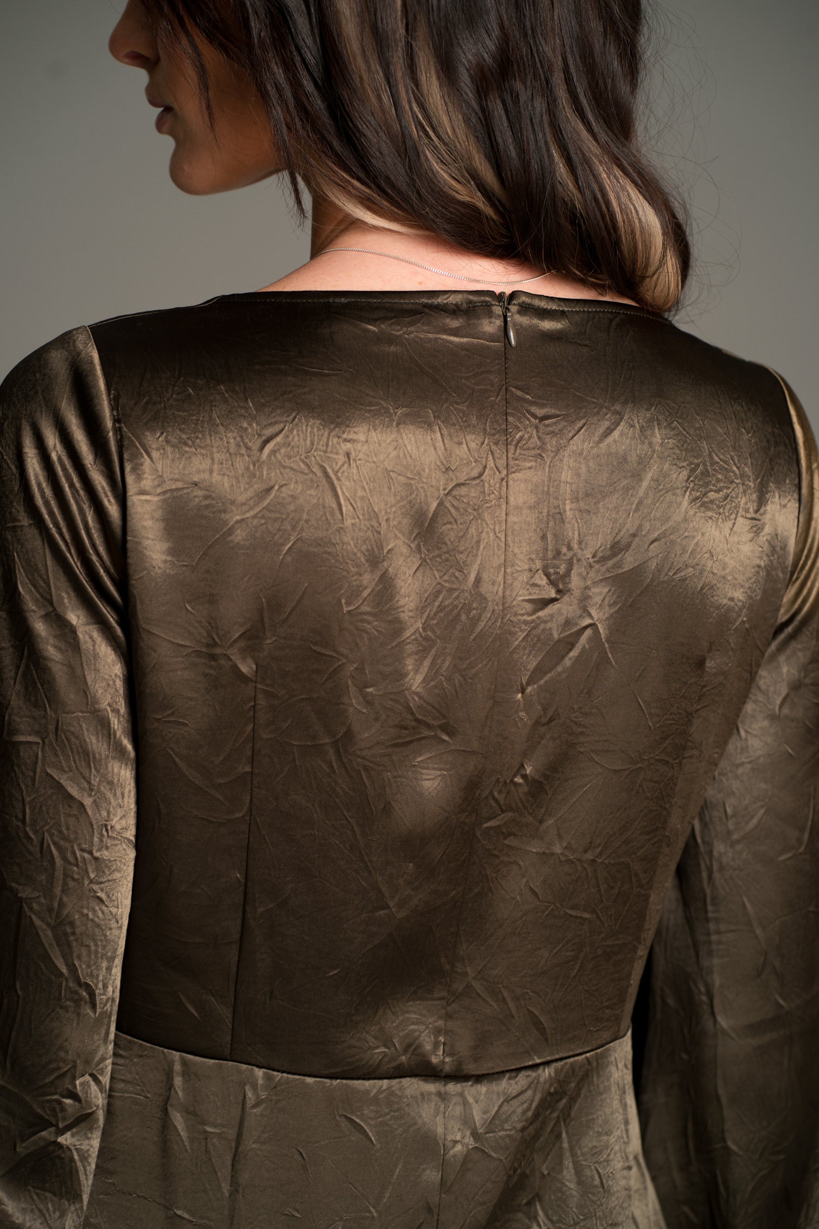 Close‑up back view of the Little Lies Arabella Satin Maxi Dress in olive satin with subtle textured finish and concealed zip detail.