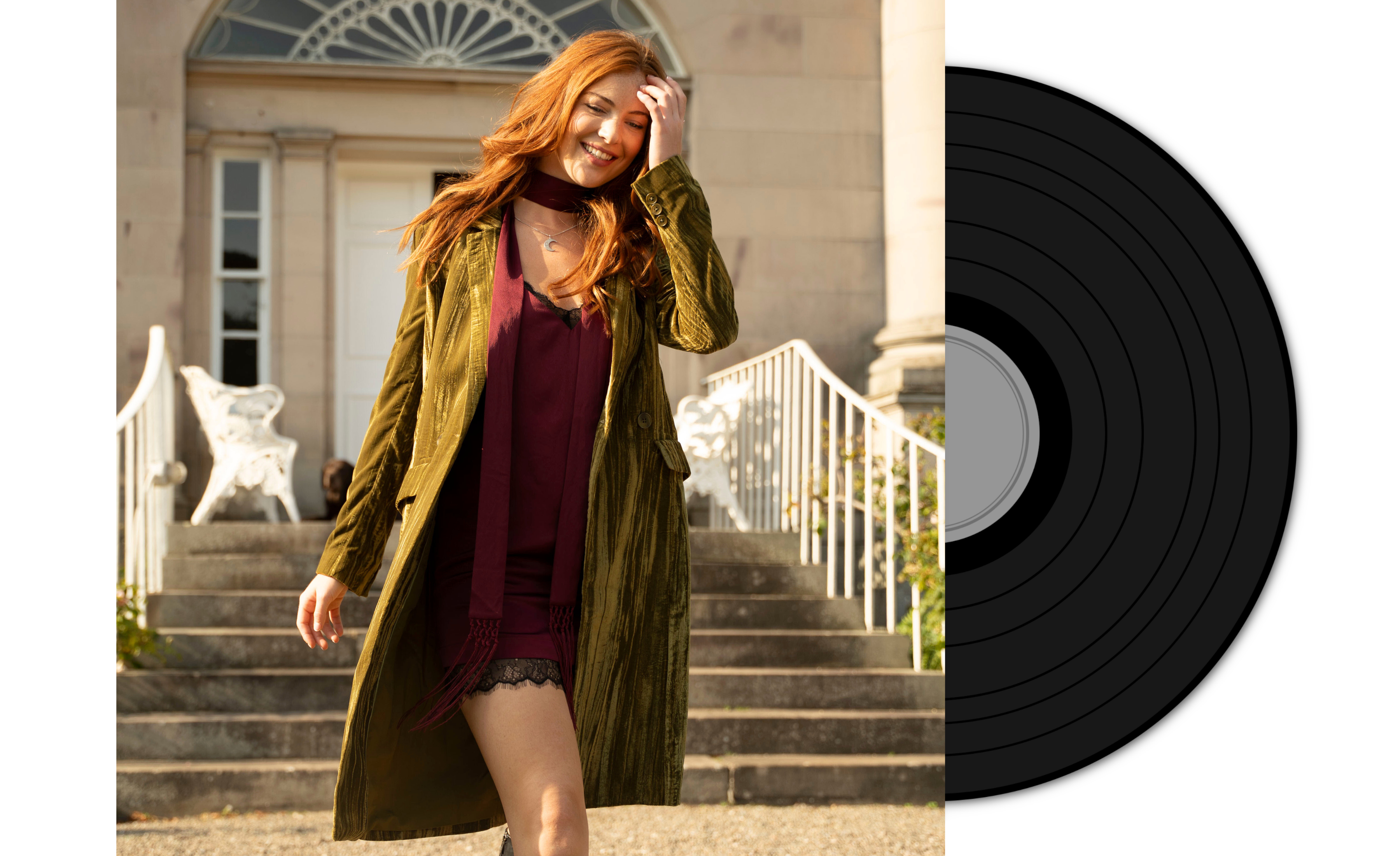 Anna wearing Jagger Olive jacket and Nightbird Plum Satin Dress standing on steps with a vinyl record on the right.