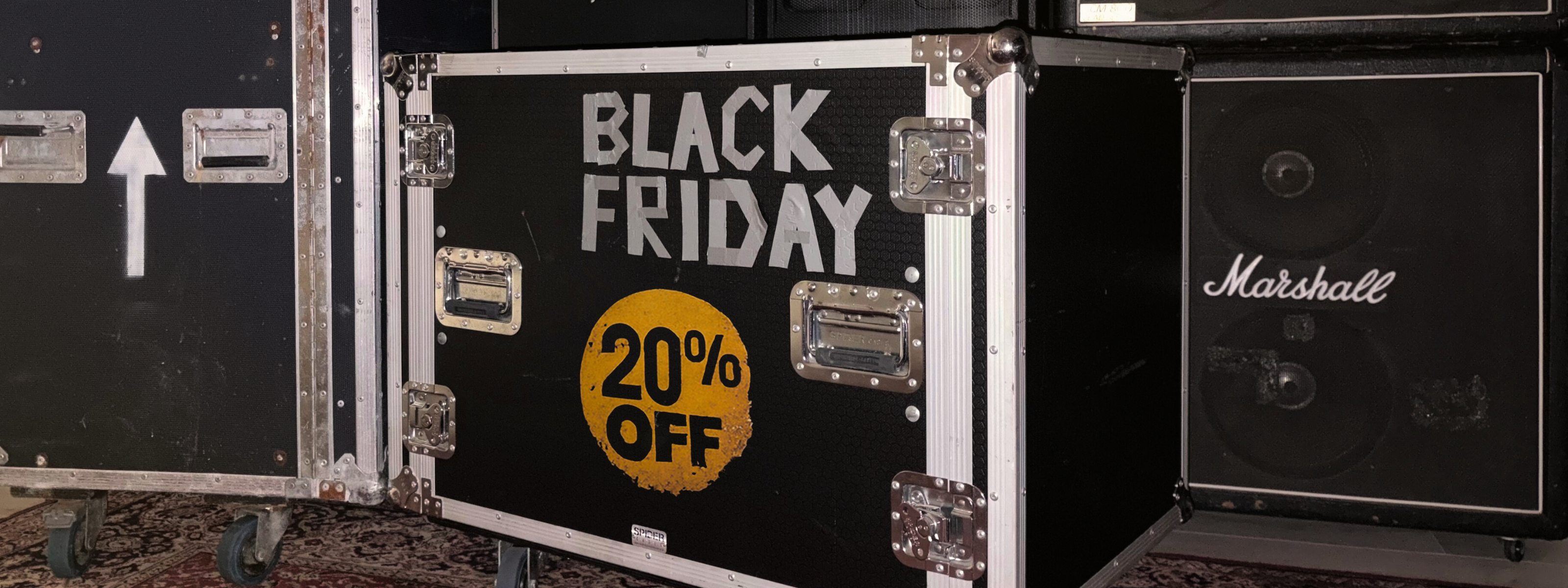 Little Lies Black Friday sale sign on flight case and Marshall amplifiers in the background.