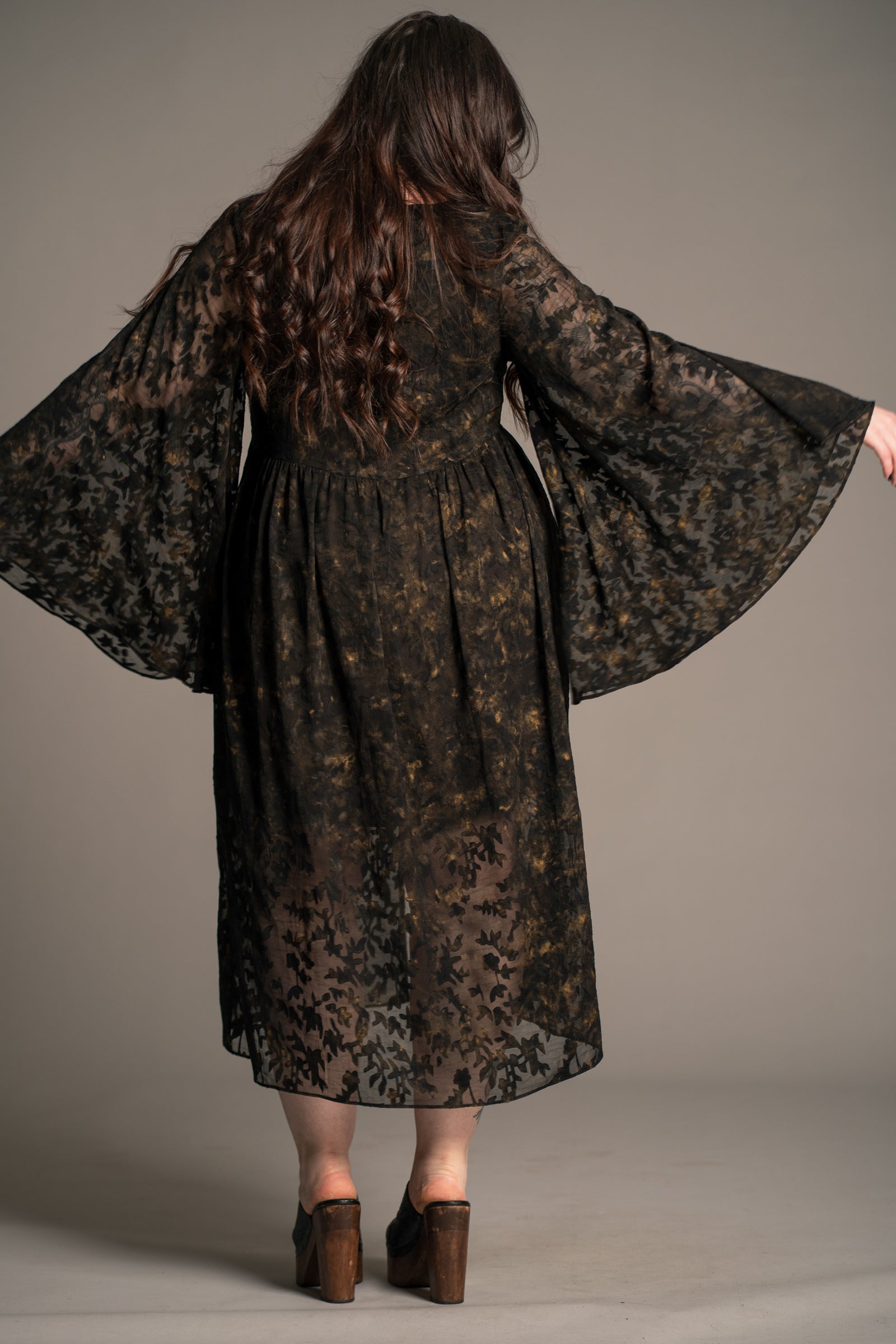Little Lies Bella Donna black lace midi dress with sheer floral overlay and wide sleeves, on‑model back view