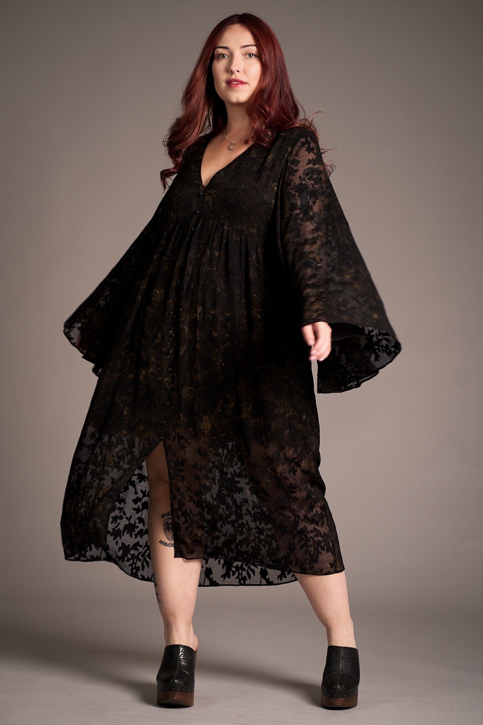 Taylor wearing Bella Donna Midi Dress featuring deep V-neckline, sheer floral sleeves, against a neutral backdrop, Stevie Nicks inspired styling studio