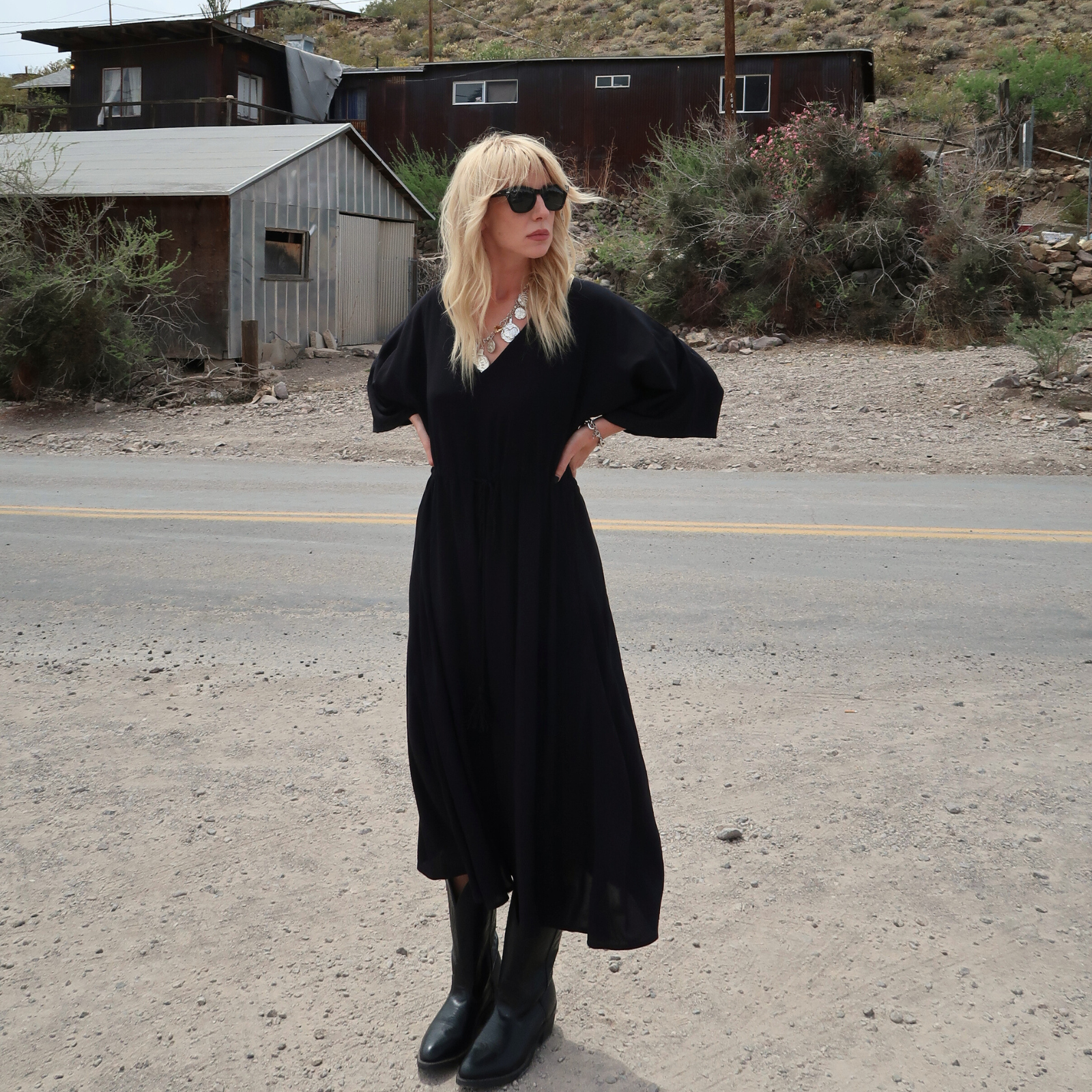 model wearing the boho Blackbird midi dress on a dusty western country road. Yeehaw!