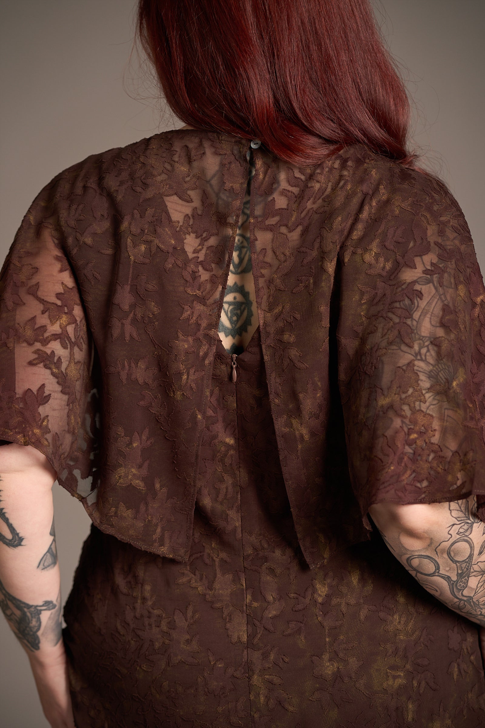 Taylor showcasing the cape and zip closure details on the Brown Sugar cape maxi chiffon dress.