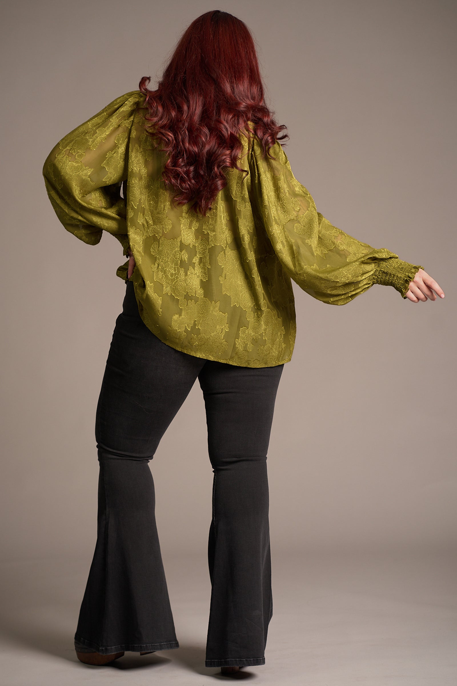 Taylor showing the back of the Cassia Olive Chiffon Smock Top, over Hendrix Denim flares. Stevie Nicks inspired styling studio