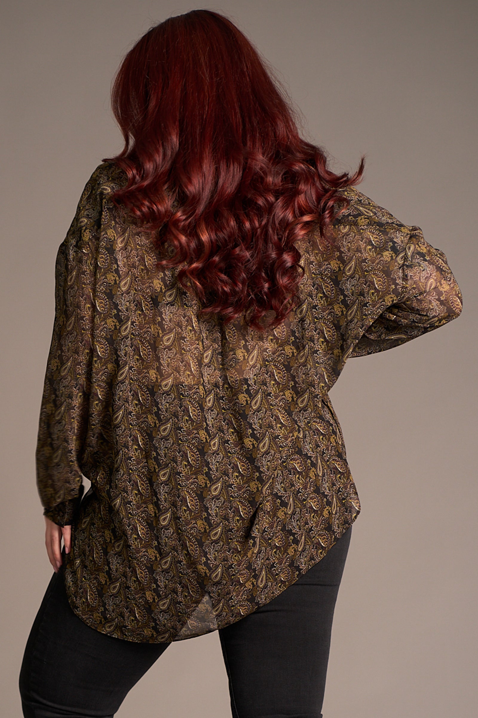 Taylor shows the back of the Cinnamon Girl Paisley Chiffon Shirt, over Hendrix Denim flares, fabric detail shot showing autumnal style.