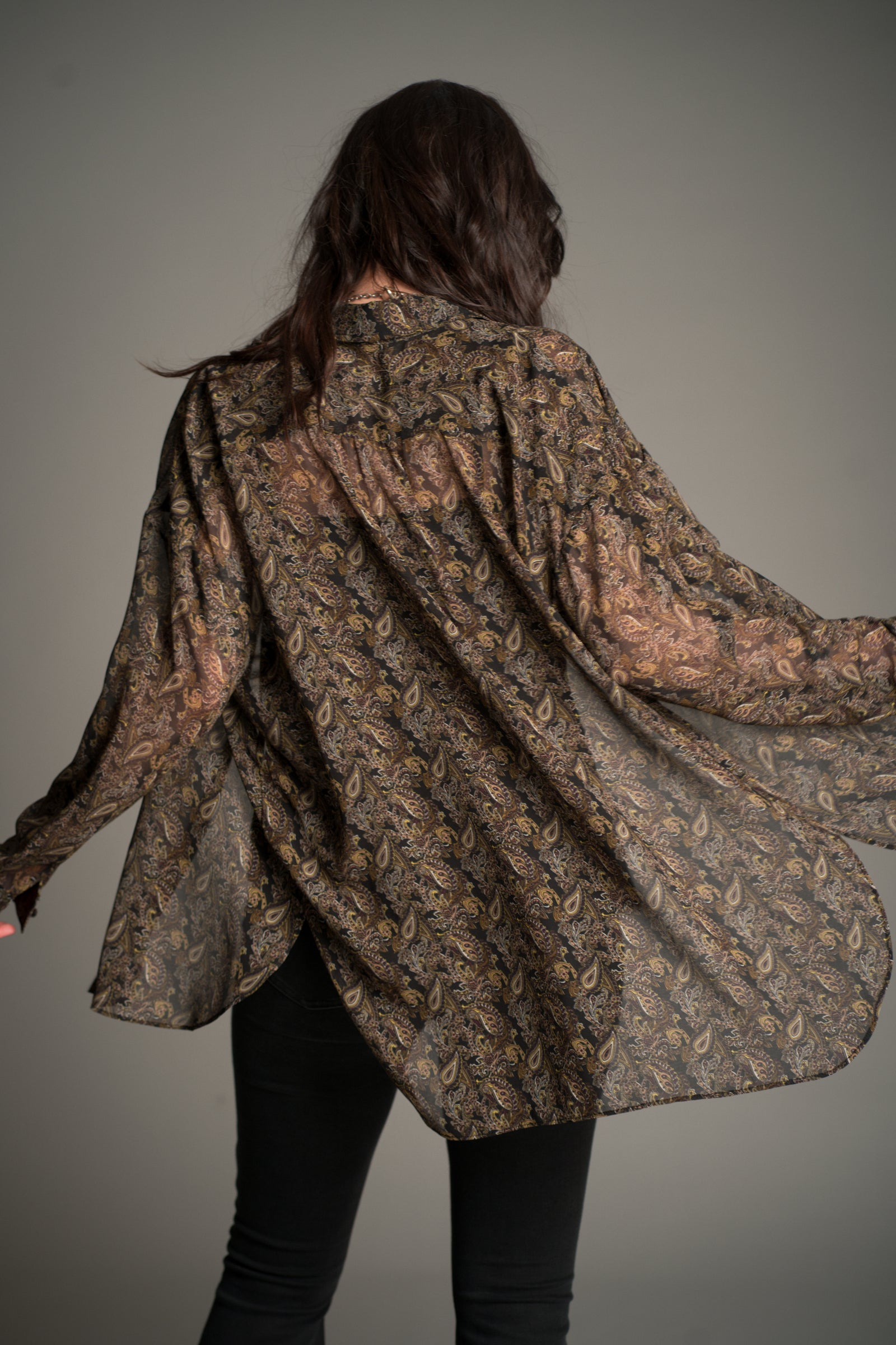 Little Lies Cinnamon Girl Paisley Chiffon Shirt shown from the back in a flowing sheer fabric with an all‑over boho paisley print.