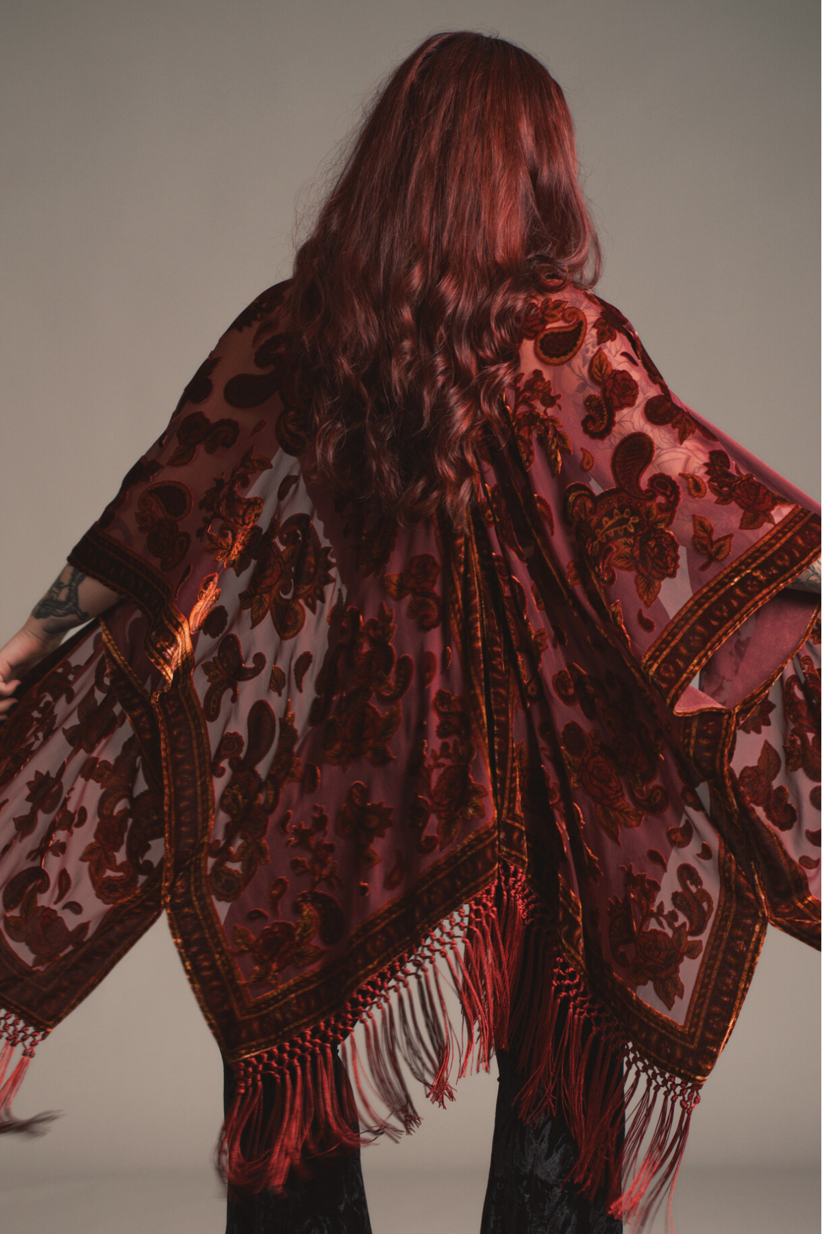 Little Lies Stevie Plum Paisley Devore Kimono with velvet burnout pattern and fringe detailing, shown from the back on a model.