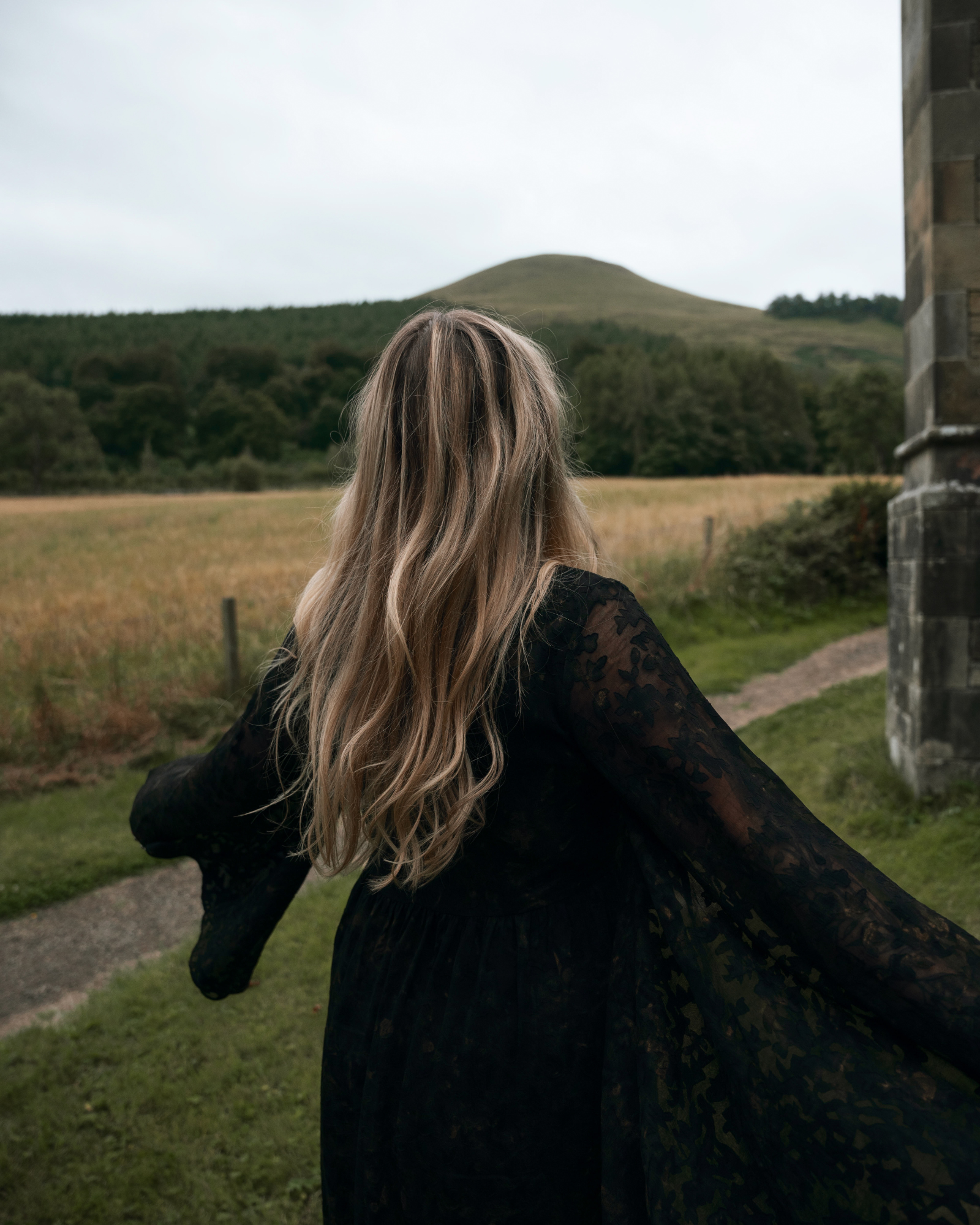 Erin twirling in the Bella Donna Midi Dress Stevie Nicks inspired styling, outdoor, set against stone ruins and woodland