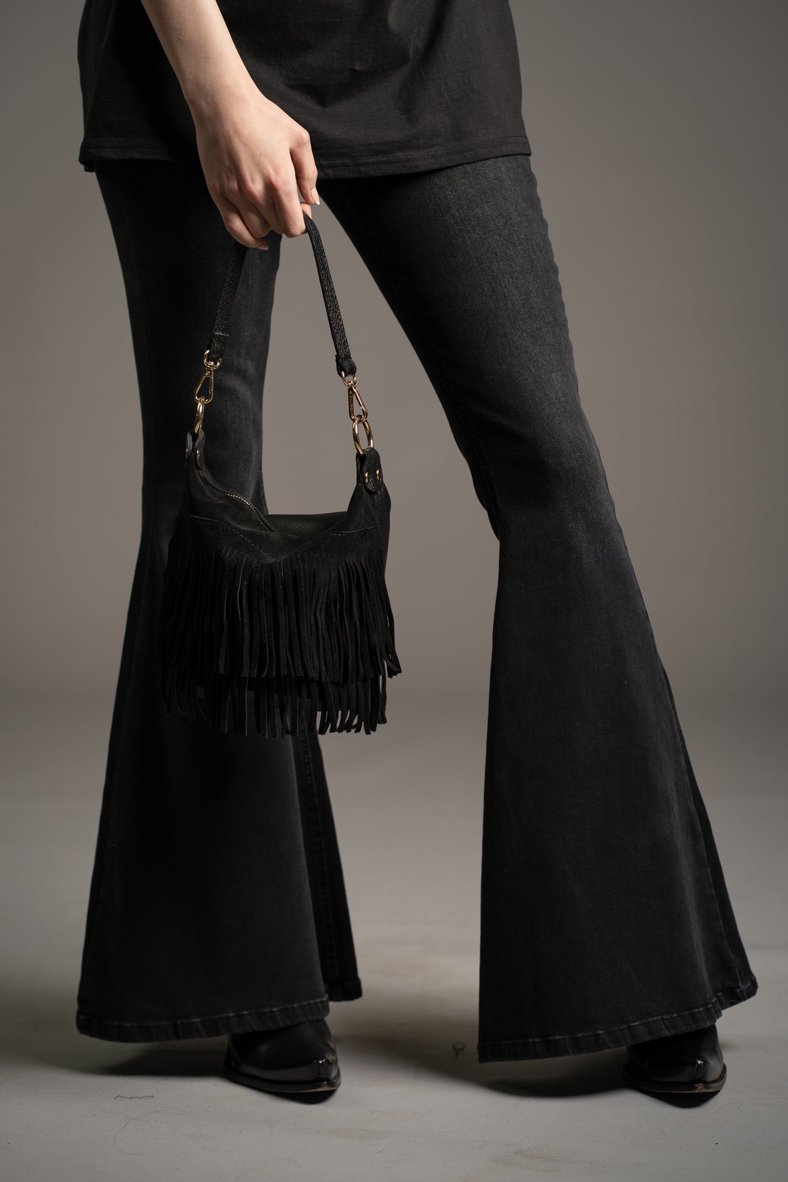 Gemini Genuine Leather Fringed Bucket Bag in black styled with Hendrix Denim flares and Fleetwood Mac band tee by Little Lies in studio setting
