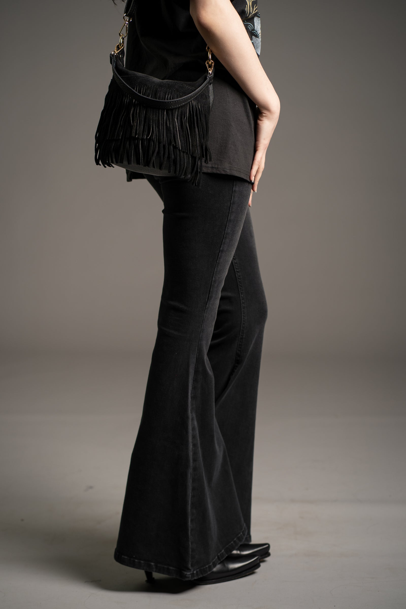 Gemini Genuine Leather Fringed Bucket Bag in black styled with Hendrix Denim flares and Fleetwood Mac band tee by Little Lies in studio setting
