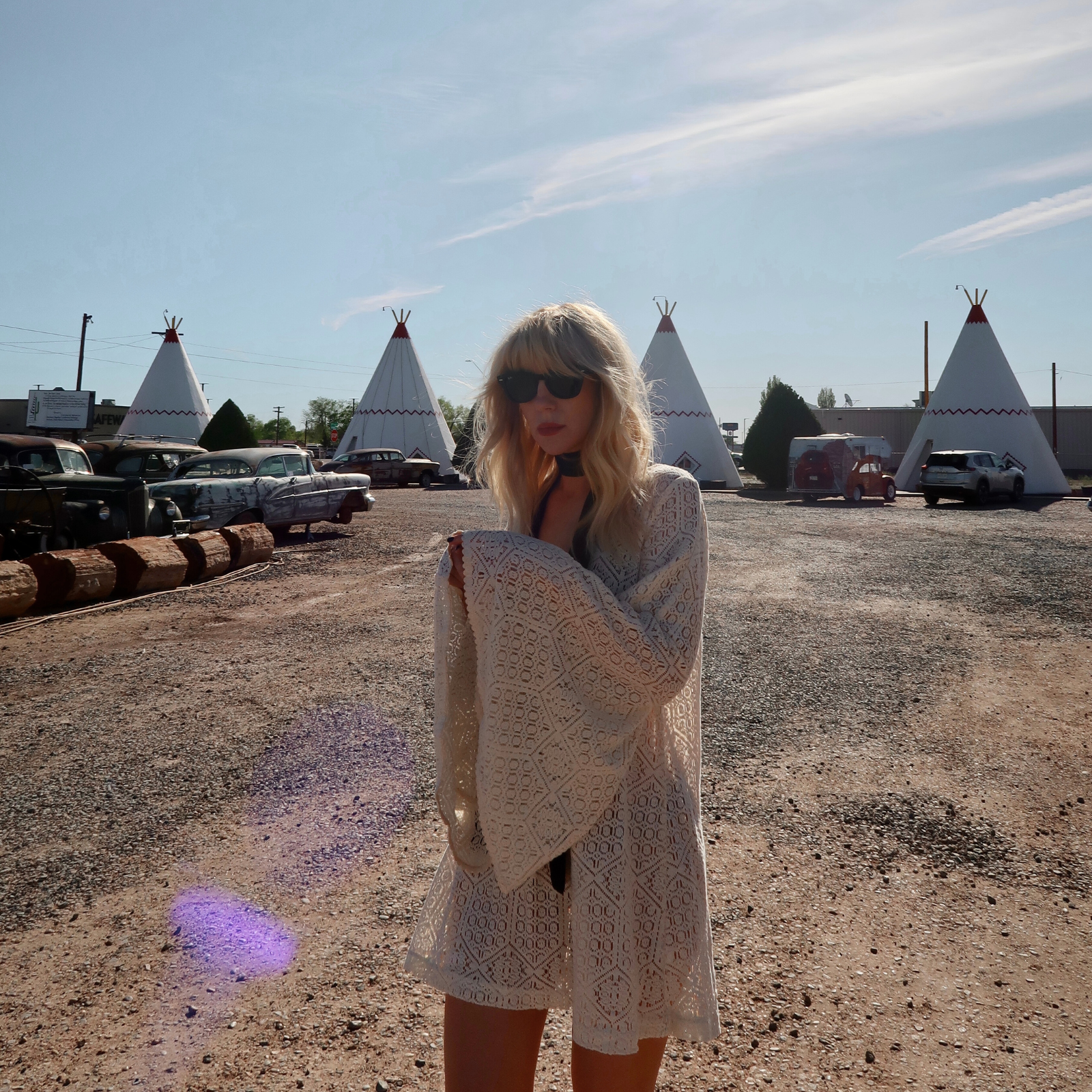 Model wearing the bohemian Goldie Ivory crochet style mini dress in a western country setting.