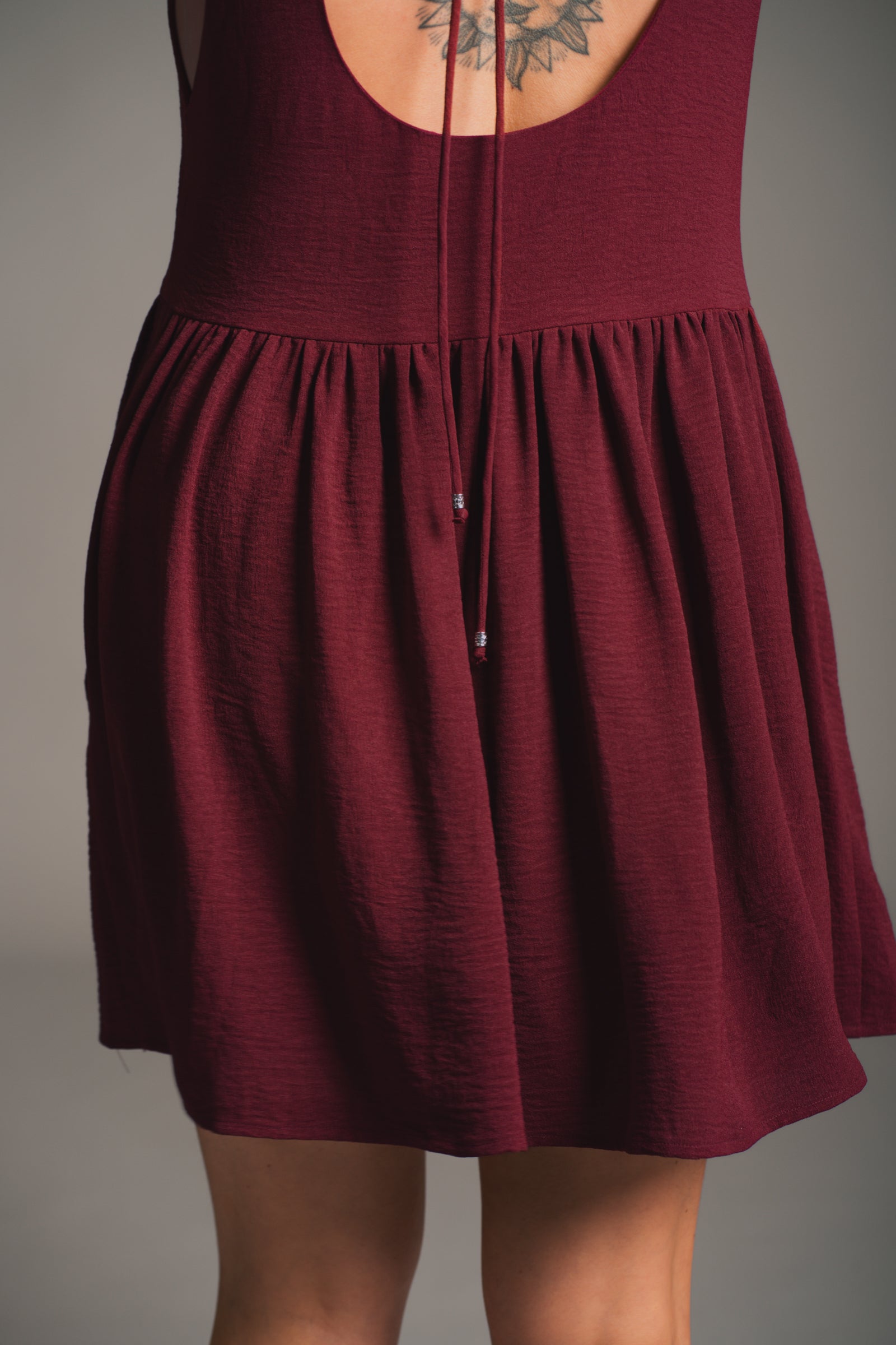 Full length view of Little Lies Grace Plum Smock Dress styled with boots