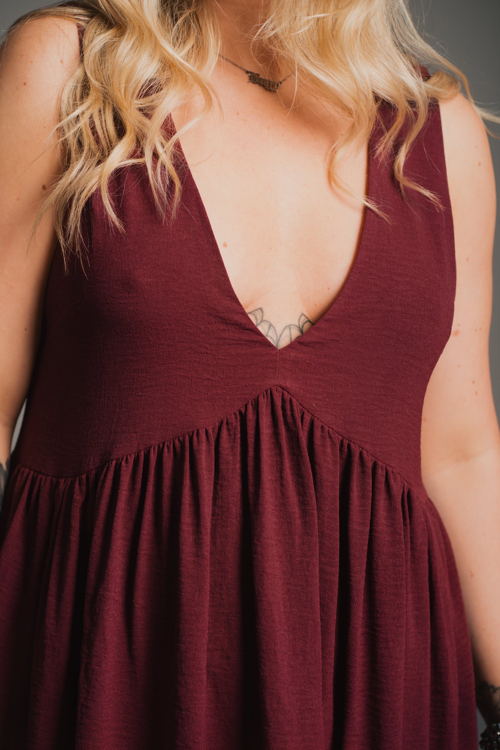 Side view of Little Lies Grace Plum Smock Dress showing relaxed smock mini silhouette