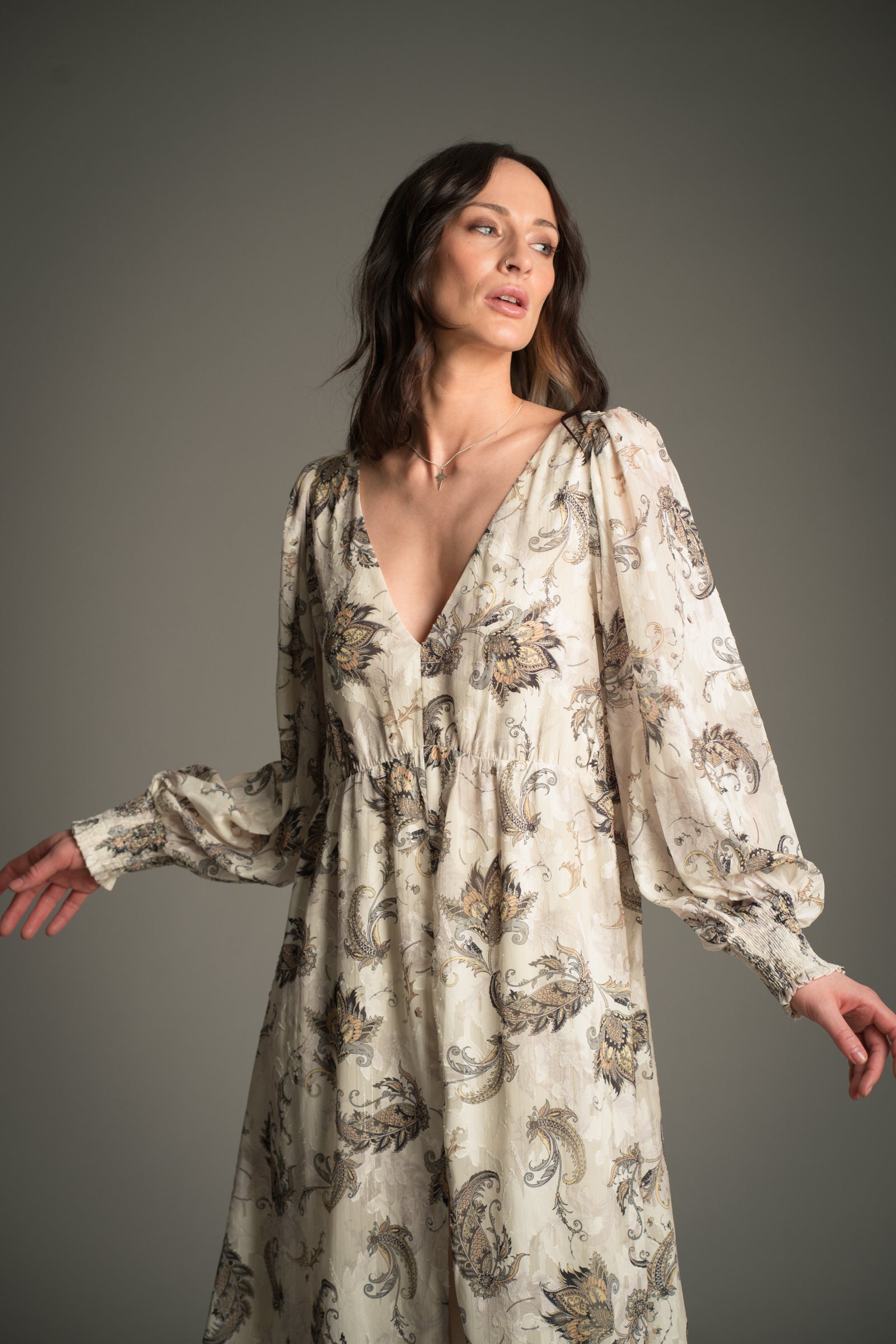 Victoria wears Little Lies Harvest Moon Paisley Midi Dress in cream with an intricate paisley print, shown from the front with long voluminous sleeves and a deep V‑neckline.