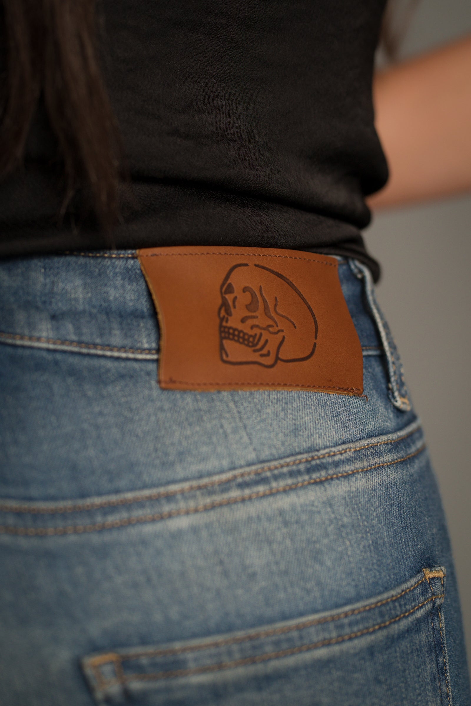 Close-up of the Little Lies signature leather logo patch on the Hendrix Blue Denim Flares.