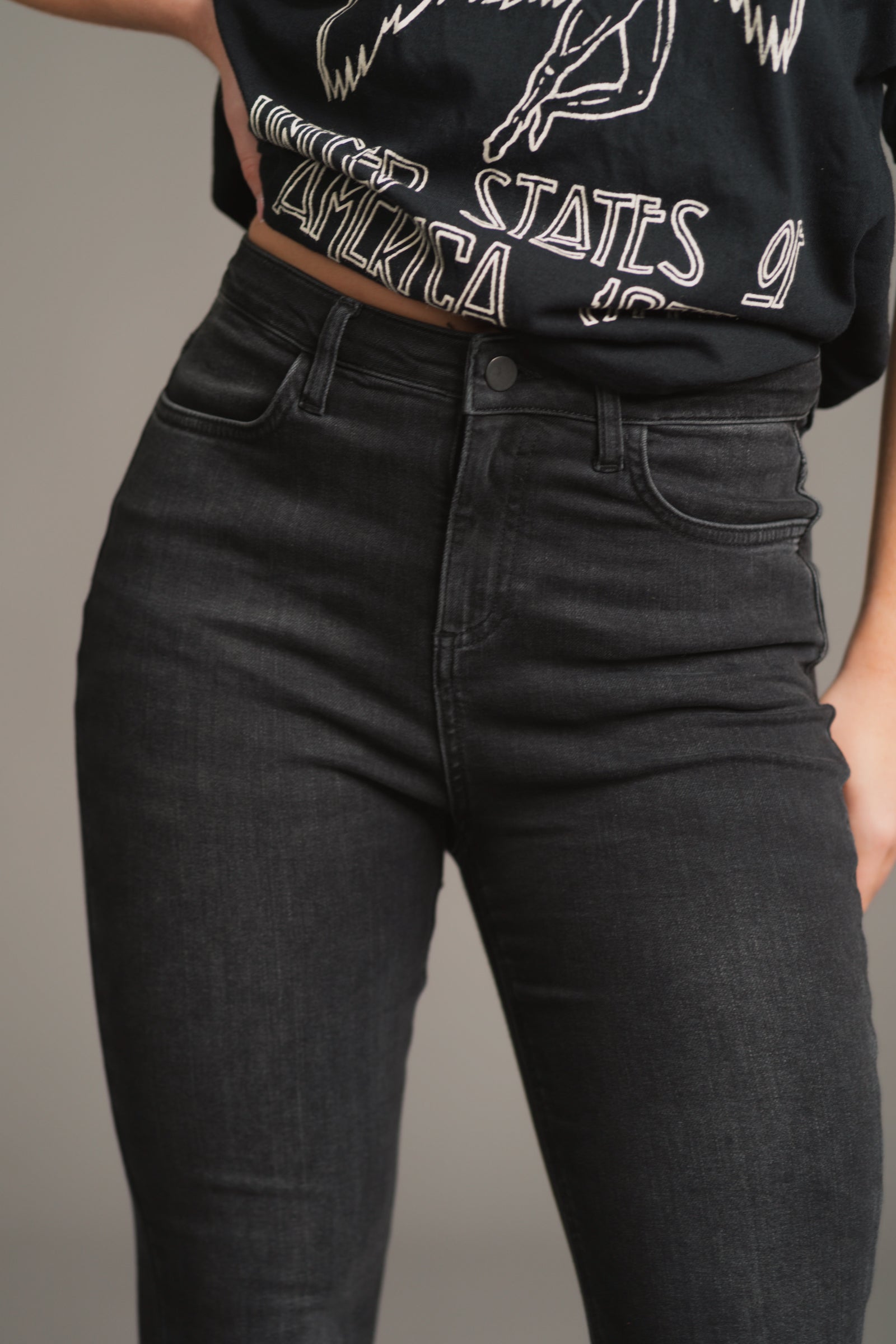 Front close-up of Little Lies Hendrix Denim Flares – high-waisted dark wash denim with a smooth, stretch-fit texture, featuring button and zip closure for a sleek, sculpted silhouette.