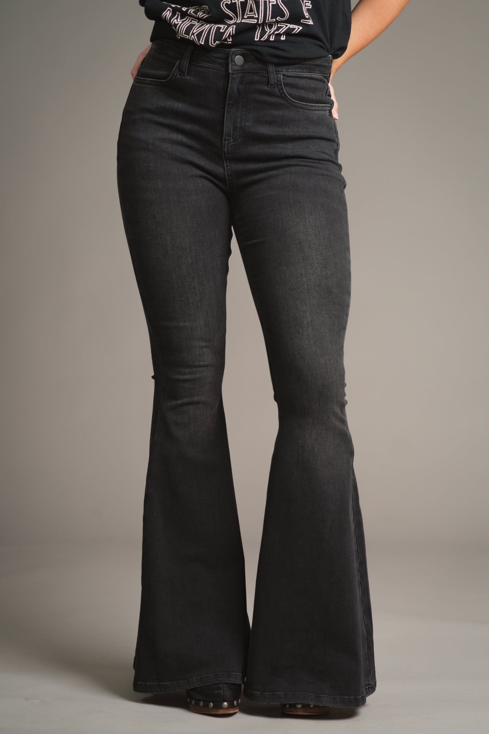 Full front view of Little Lies Hendrix Denim Flares – high-waisted dark wash denim with subtle fading, and dramatic flare from knee to hem for a bold retro-inspired silhouette