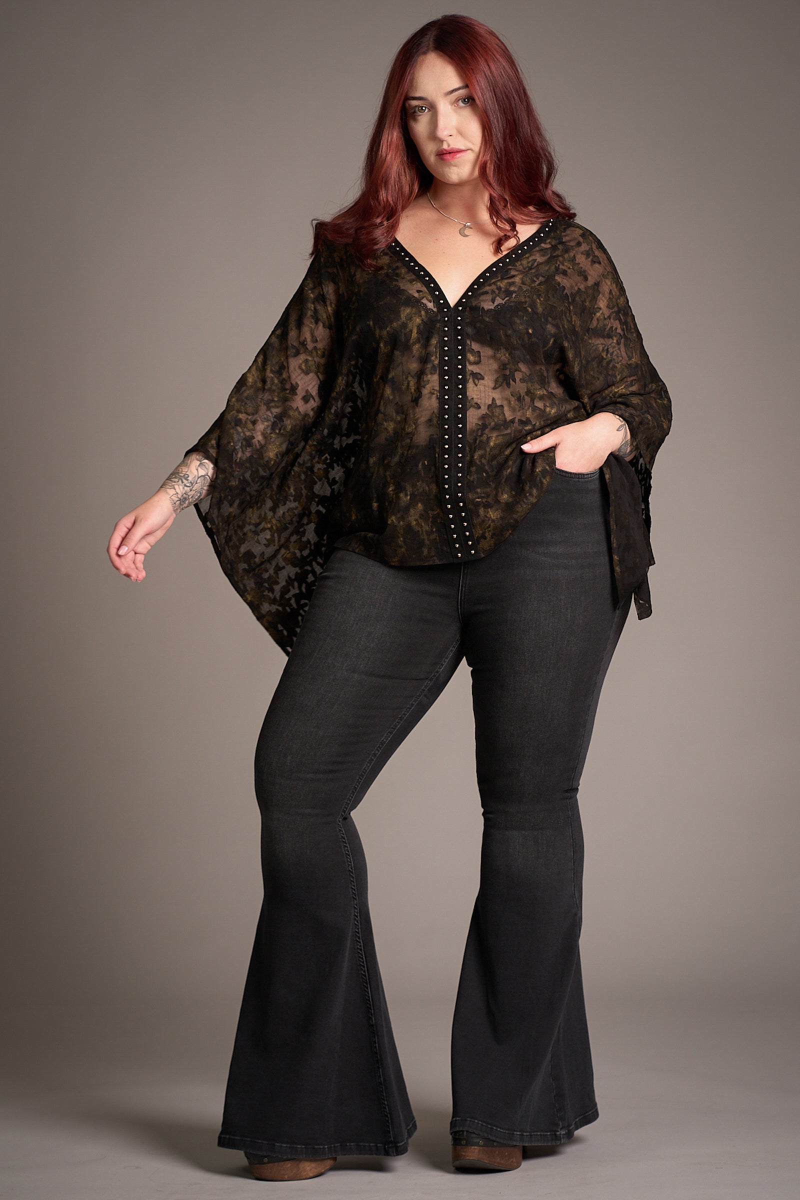 Taylor wears Little Lies Hendrix Denim Flares with the Bella Donna Kimono – high-waisted flares paired with a sheer, patterned kimono top featuring wide sleeves, styled in a minimalist studio setting.