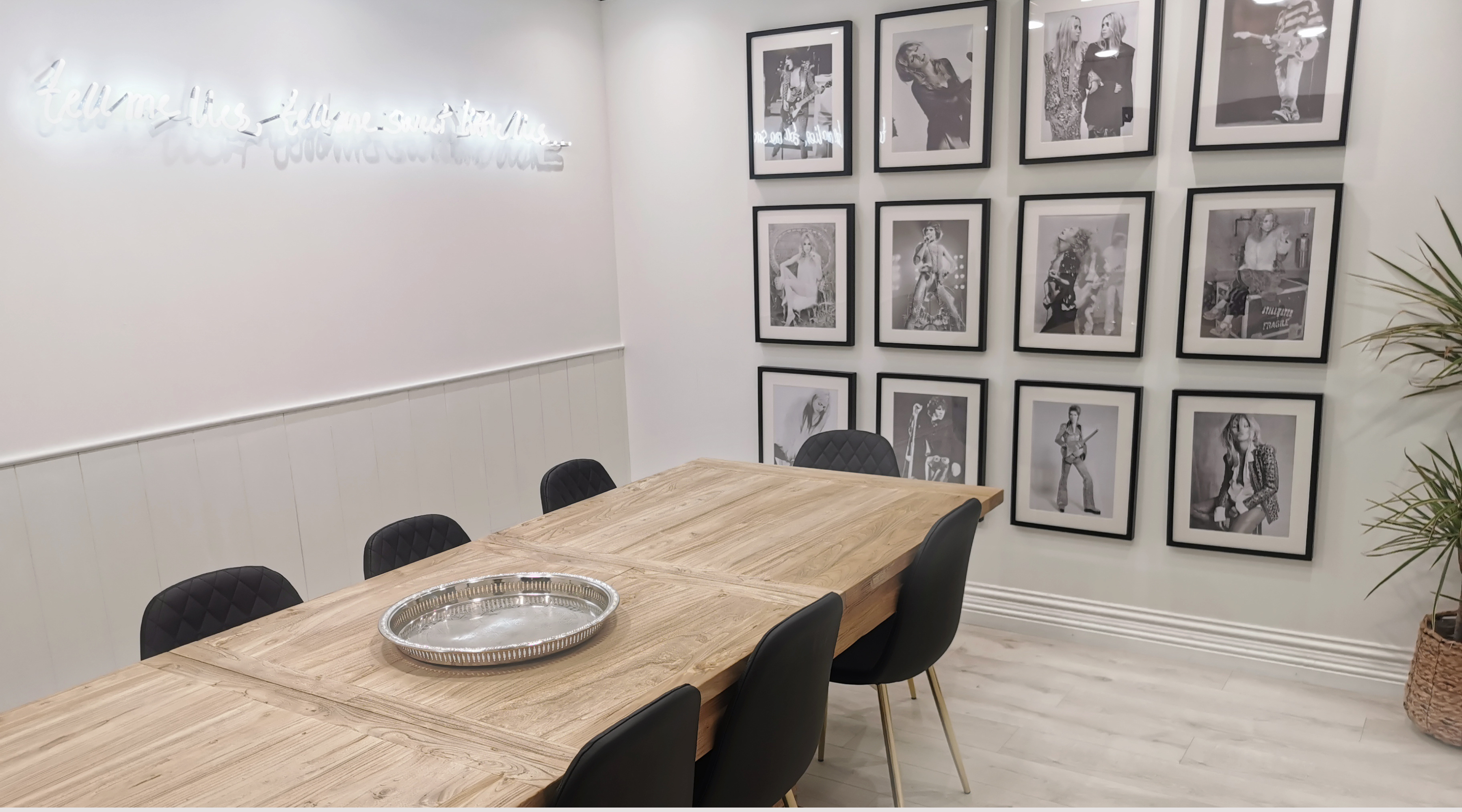 Little Lies meeting room, with Iconic Portraits on the wall, Including Stevie Nicks, David Bowie Kate moss, and other boho rock 'n roll décor.