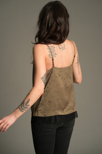 Back angled view of the Little Lies Iris Satin Cami in sage satin with tonal floral jacquard and black lace trim, styled with black jeans.