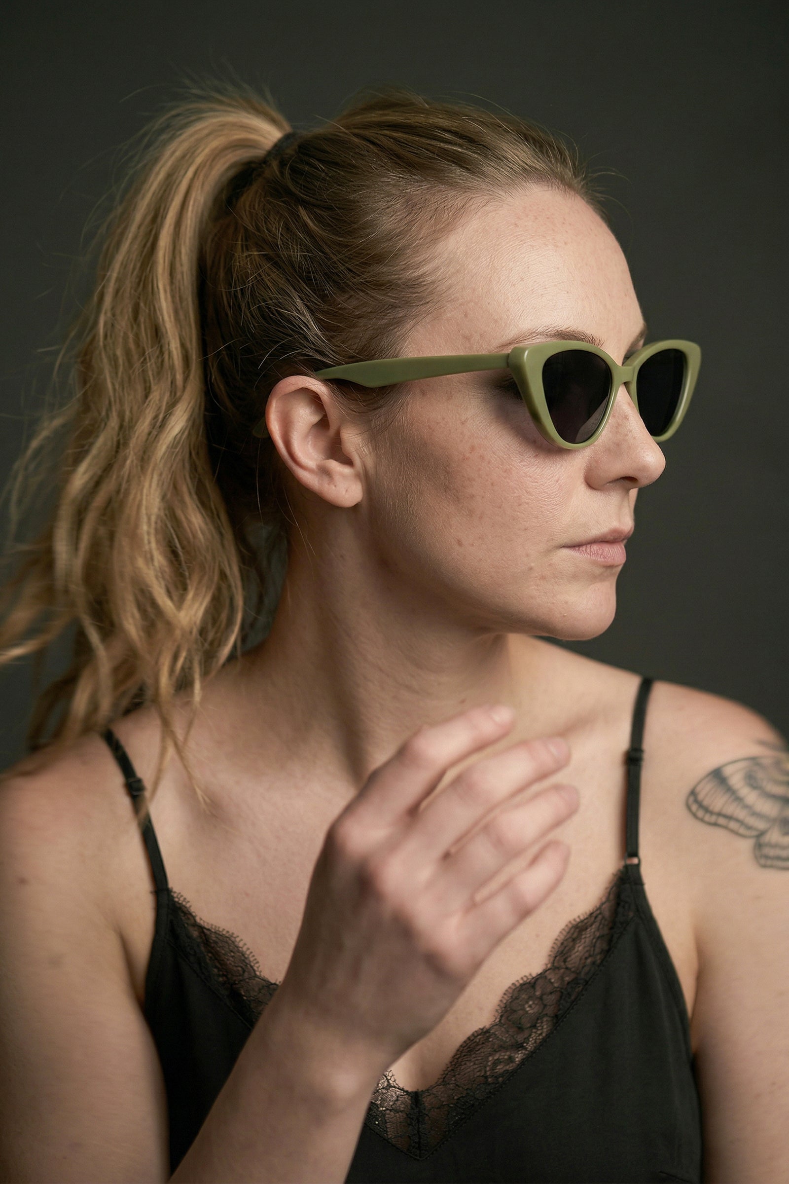 Model wearing olive cat eye sunglasses styled with Nightbird Black Cami Top