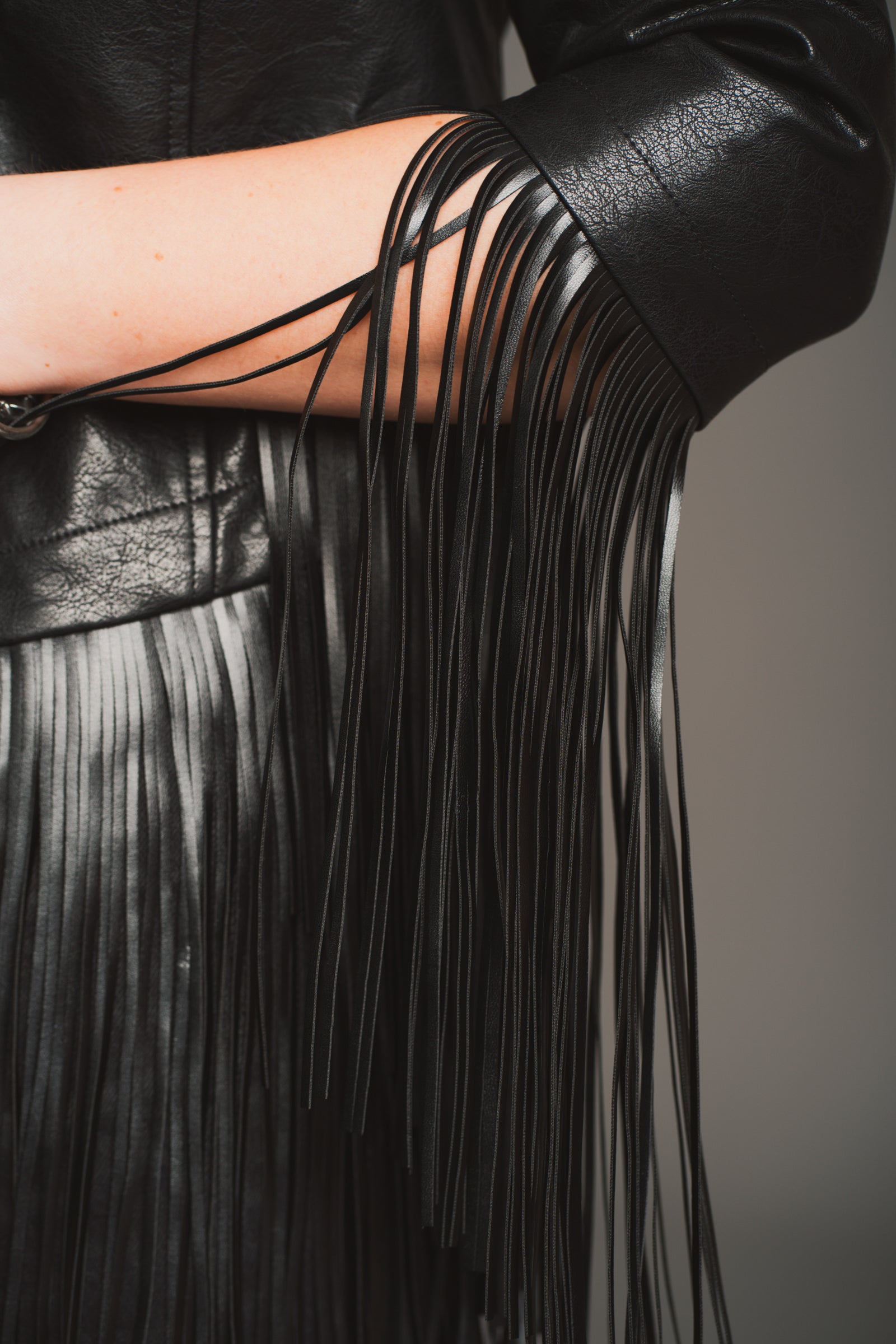 Full length model view of Little Lies Jagger Fringed Faux Leather Jacket styled with flares