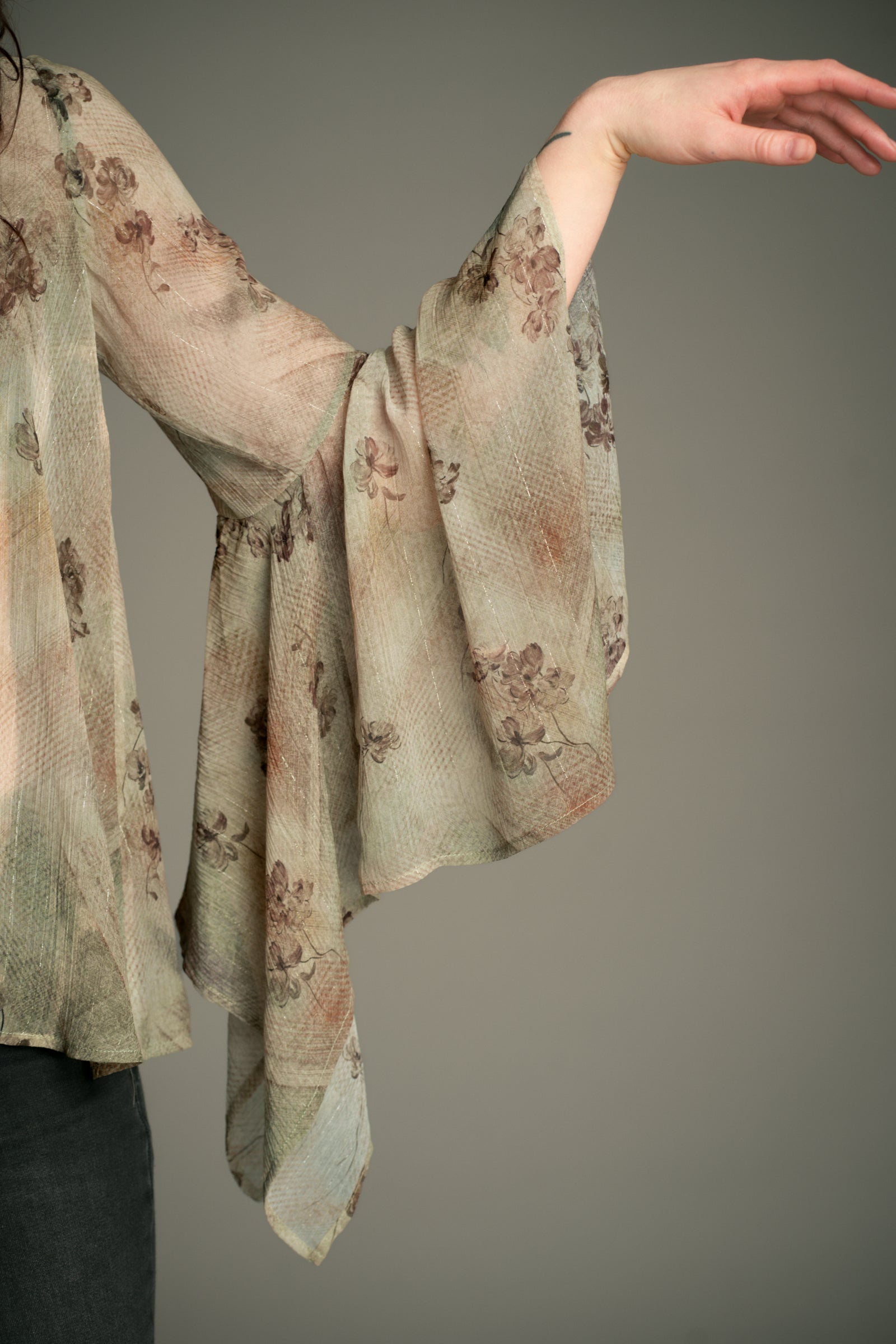 Close‑up of the Little Lies Karma Sage Blouse showing the flowing hanky‑hem sleeve in sage floral fabric