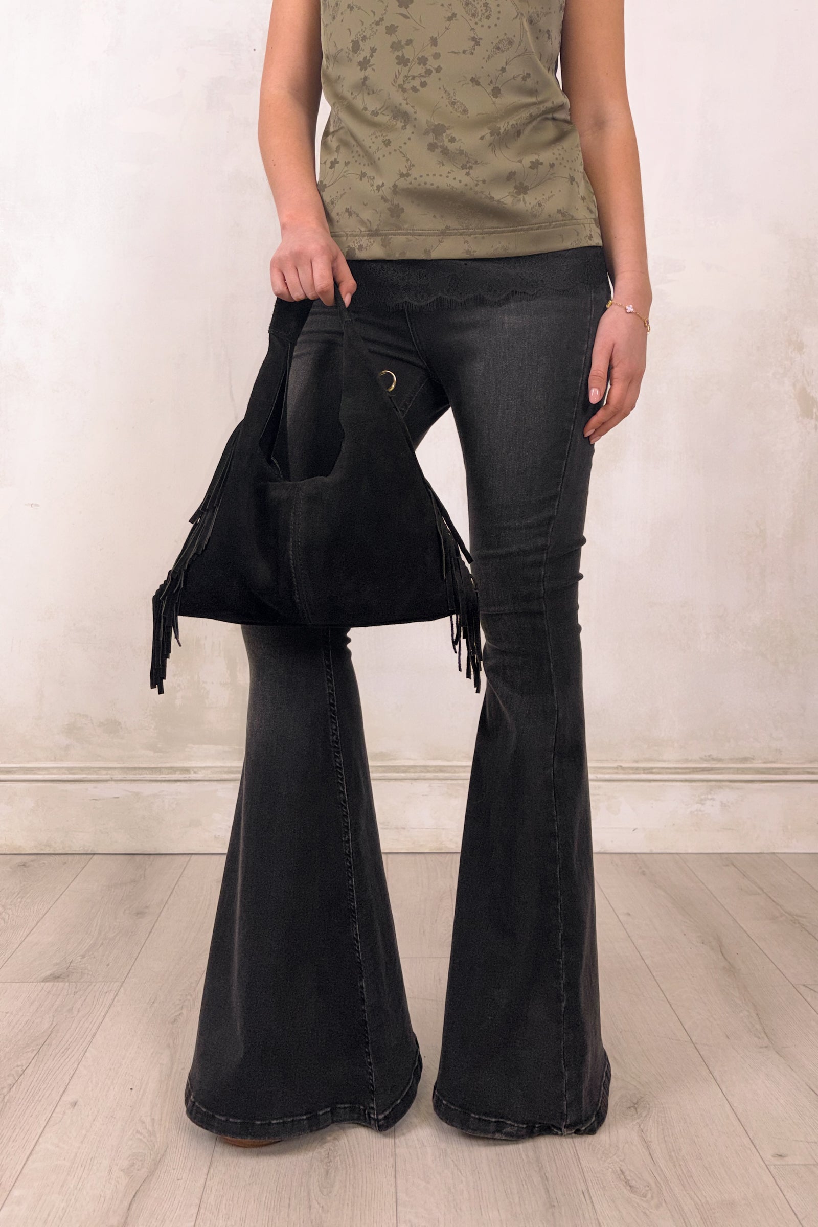 Little Lies Lila black genuine suede fringed grab bag shown in an on‑body styling featuring the Iris Satin Cami and Hendrix Denim Flares, shot in the studio.