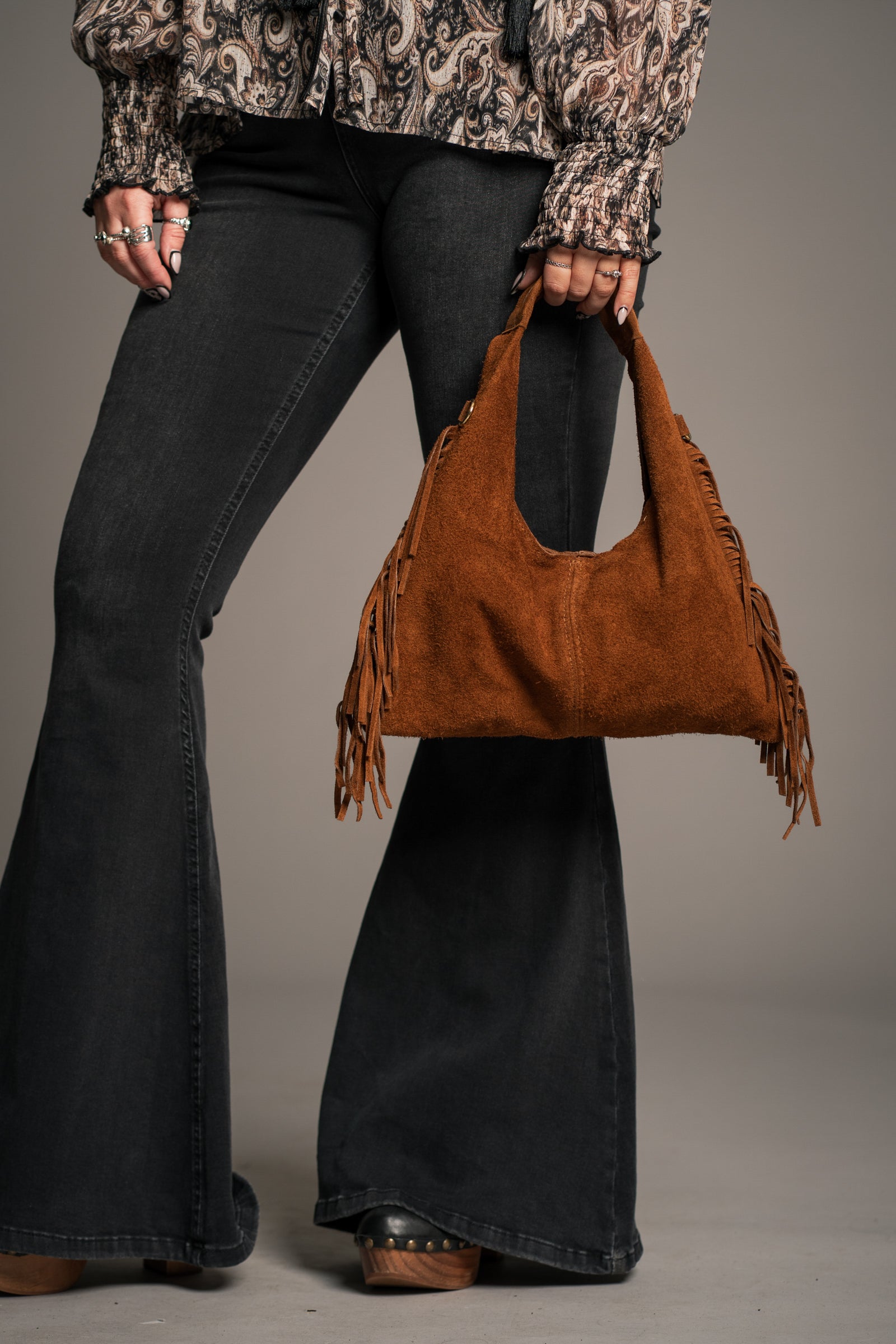 Little Lies Lila tan suede fringe bag – grab bag style worn with flared jeans and paisley blouse