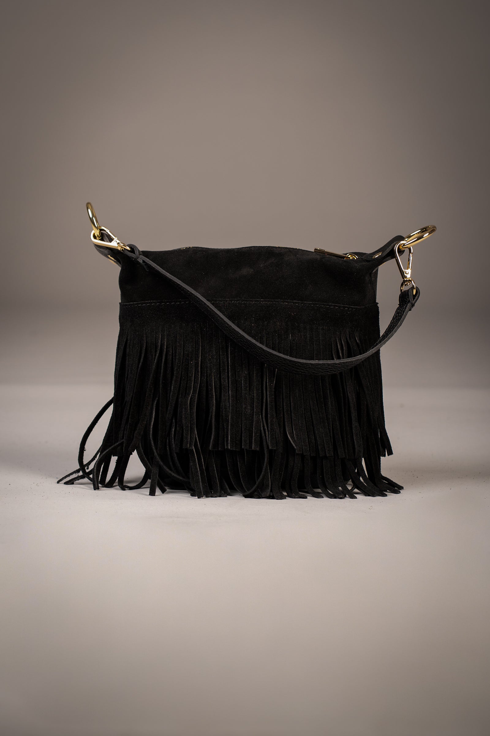 Gemini Genuine Leather Fringed Bucket Bag in black with layered suede fringe and gold hardware photographed in studio on neutral background by Little Lies