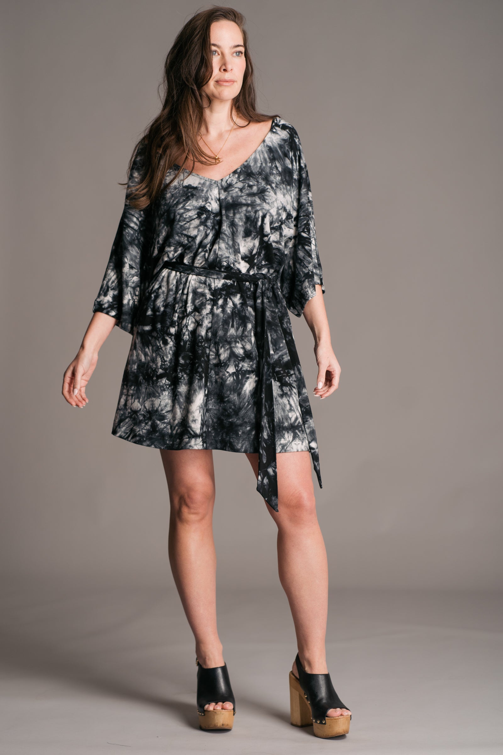 Joplin Tie Dye Mini Dress worn onset by brunette model, Bex, also wearing black leather wooden clogs.