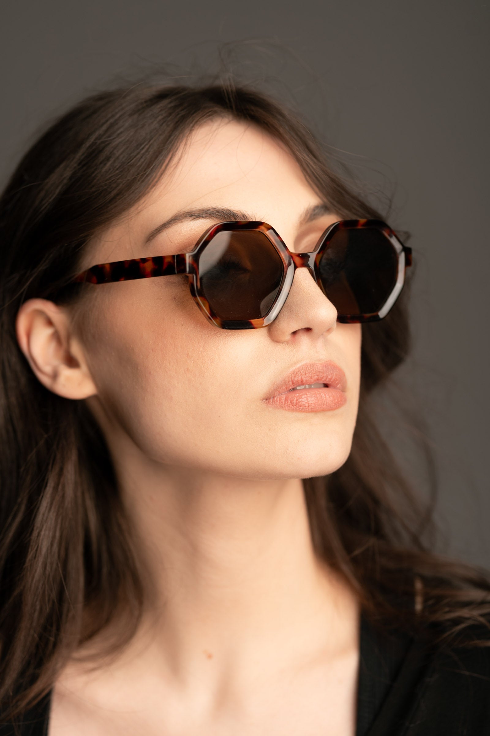 Little Lies Mary-Kate hexagon tortoiseshell sunglasses styled with dark wavy hair and a black outfit