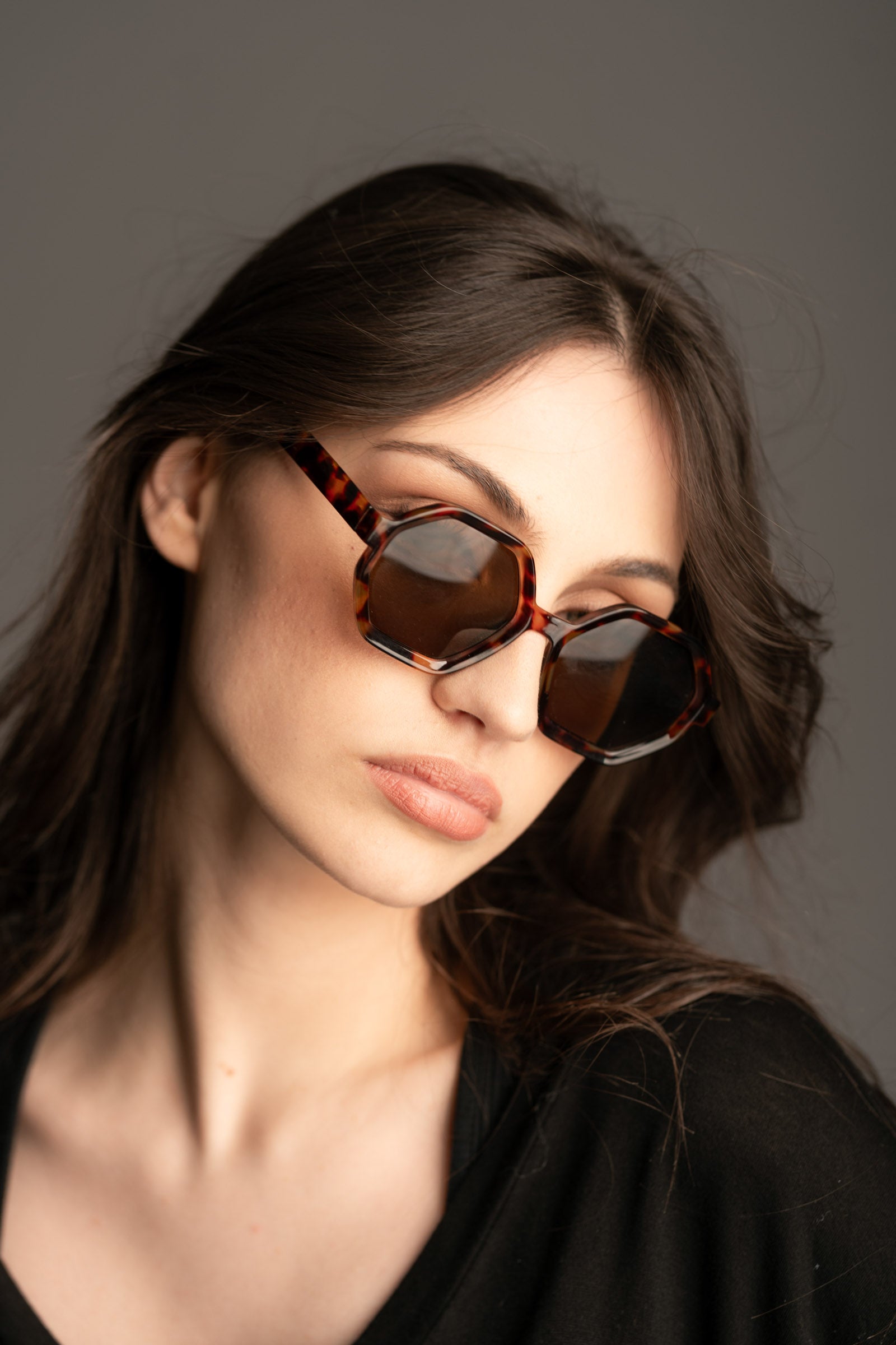 Little Lies Mary-Kate hexagon tortoiseshell sunglasses styled with dark wavy hair and a black outfit