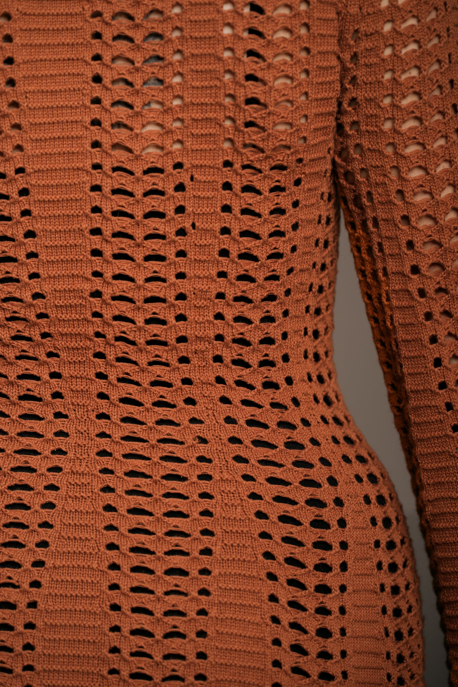 Close up shot of the intricate detail of the Little Lies Marianne Rust Crochet Mini Dress fabric.