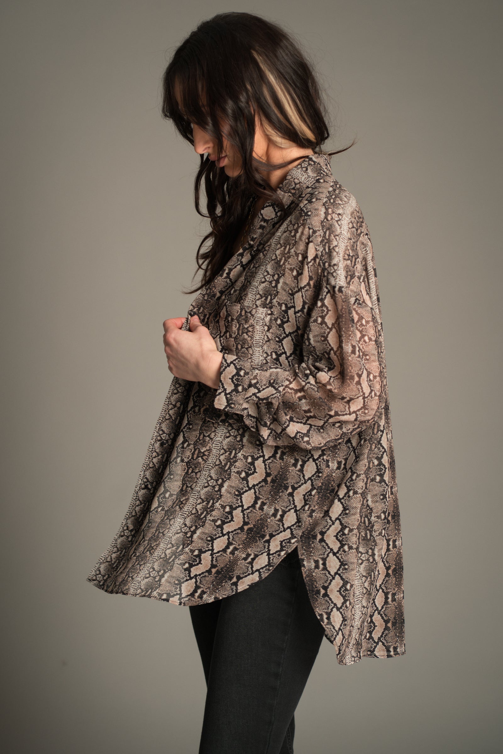 Victoria wears Little Lies Mosshart Snake Chiffon Shirt in sheer snake print, side view showing lightweight longline silhouette.