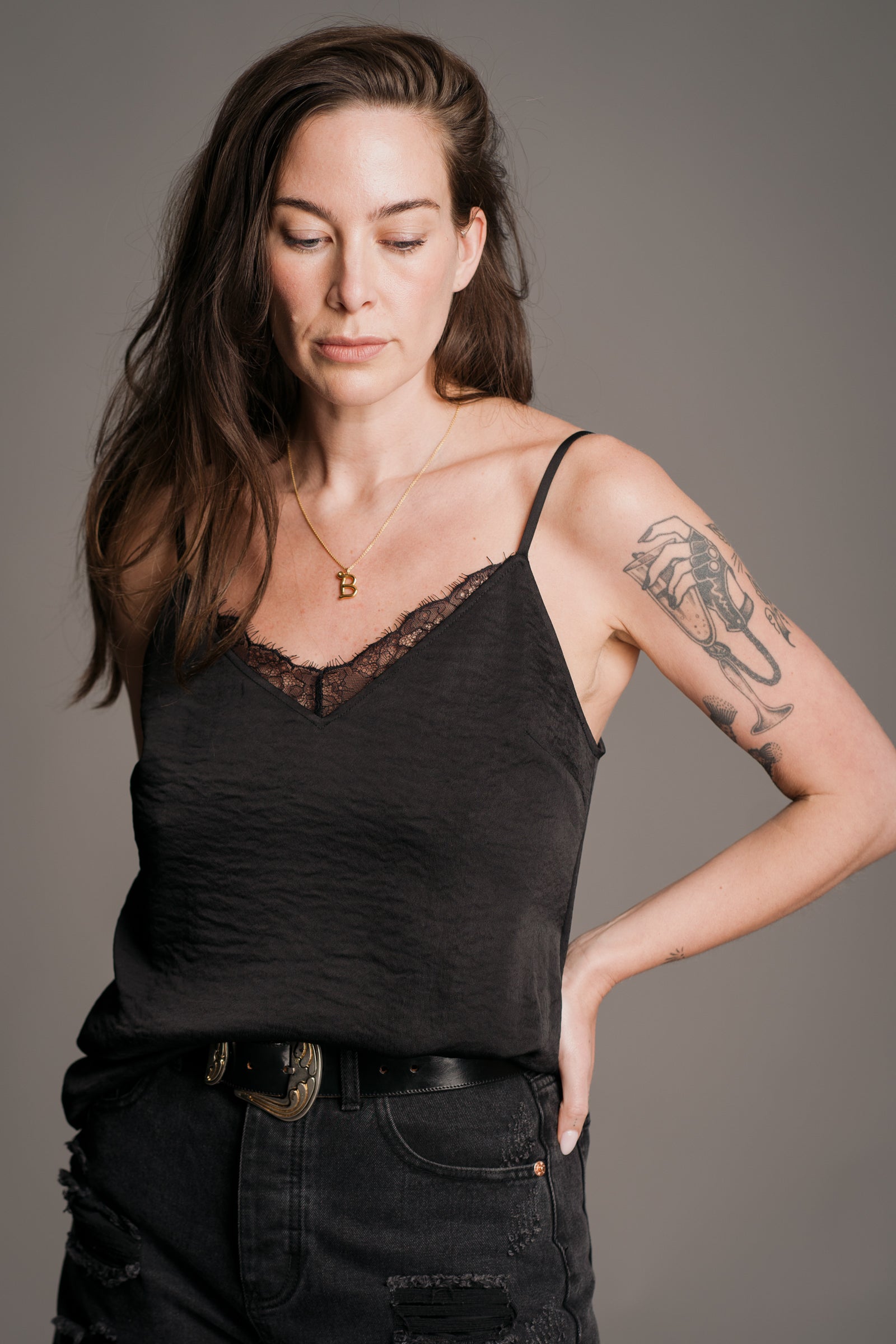 Bex models Little Lies Nightbird lace trim cami top in black – styled with distressed black jeans and western belt