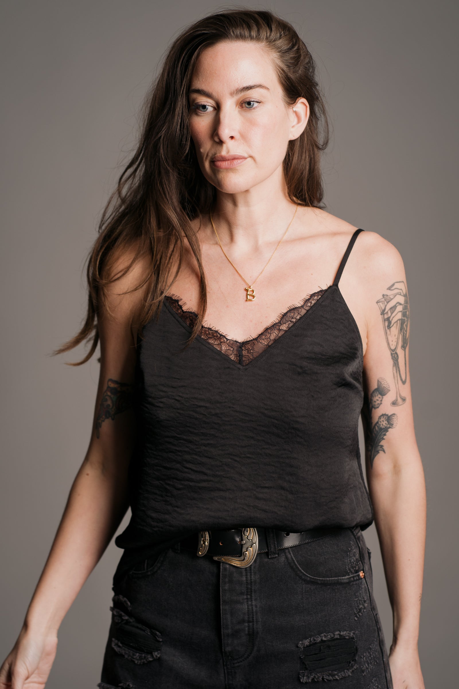 Bex models Little Lies Nightbird lace trim cami top in black – styled with distressed black jeans and western belt