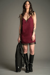 Victoria posing in plum Nightbird Satin mini dress with lace trim and black knee high boots