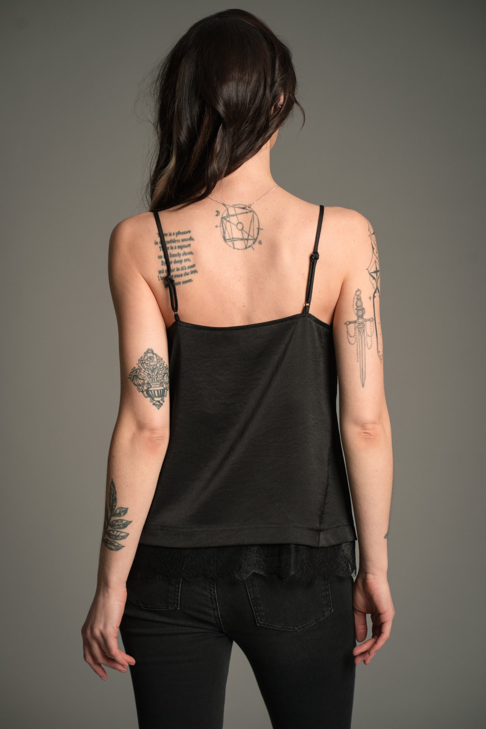 Victoria wears Little Lies Nightbird Lace Trim Cami Top in black, back view showing adjustable straps and lace‑trim hem.