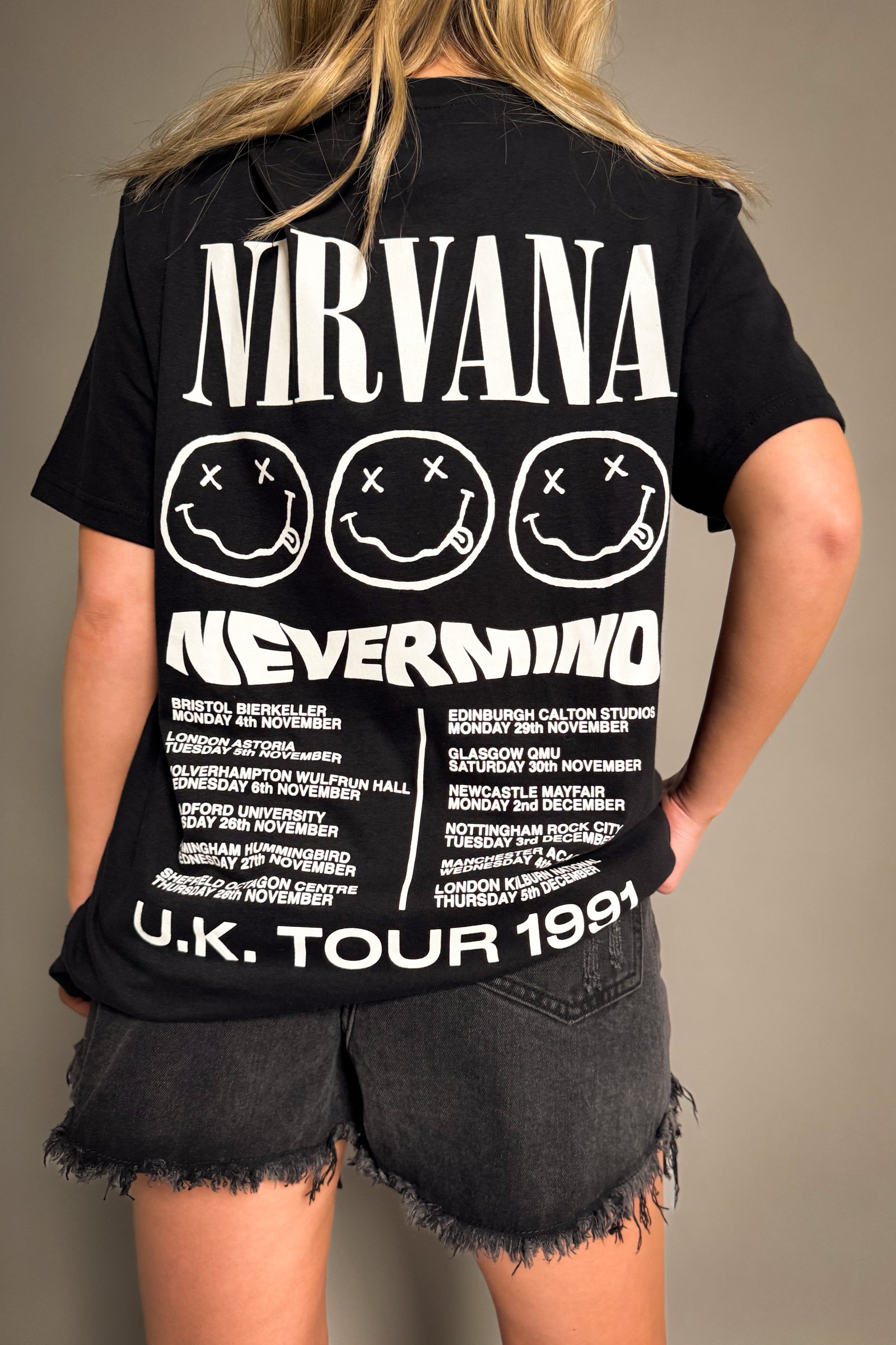 Back view of Little Lies Nirvana Nevermind 1991 UK tour band tee with smiley face graphics and printed tour dates in vintage rock style