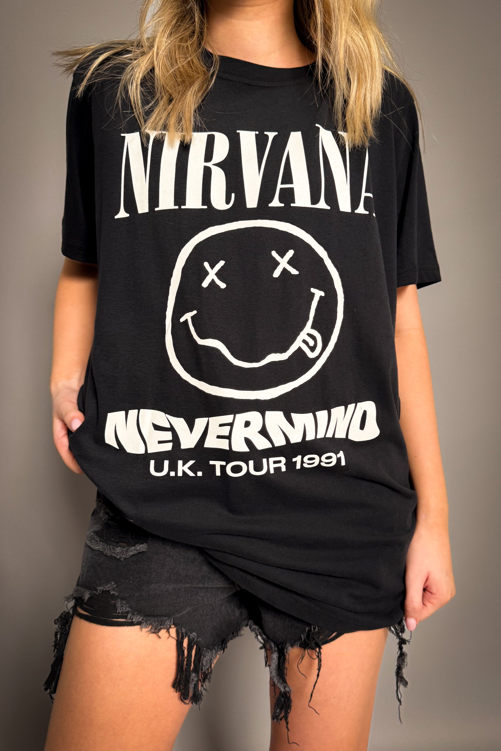 Little Lies Nirvana Nevermind Tour 1991 band tee in black with iconic smiley face graphic and vintage-style logo in relaxed oversized fit