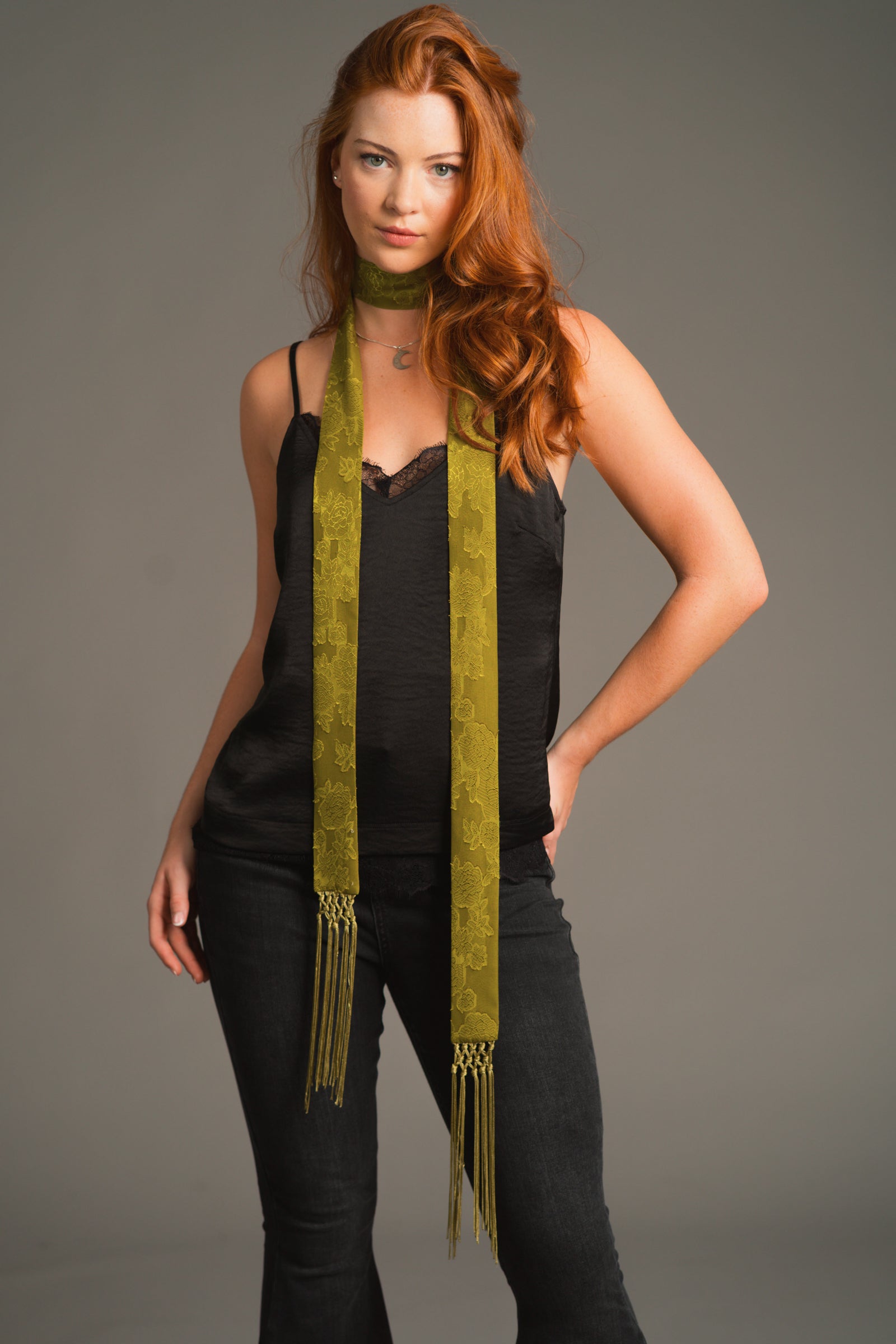 Olive boho skinny scarf tied around neck, paired with black Nightbird Cami top and black jeans.