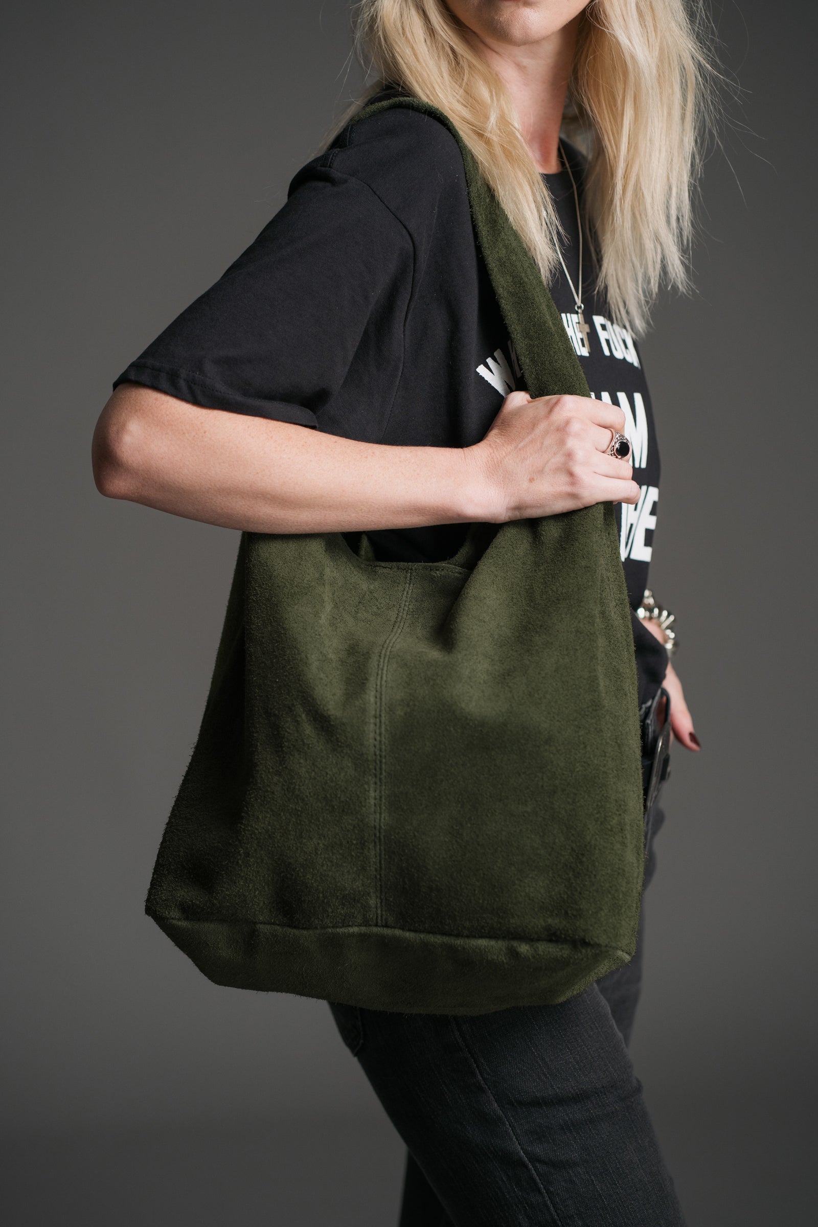 Olsen Khaki Genuine Suede Slouchy Bag worn over the shoulder with a black graphic tee and dark denim.