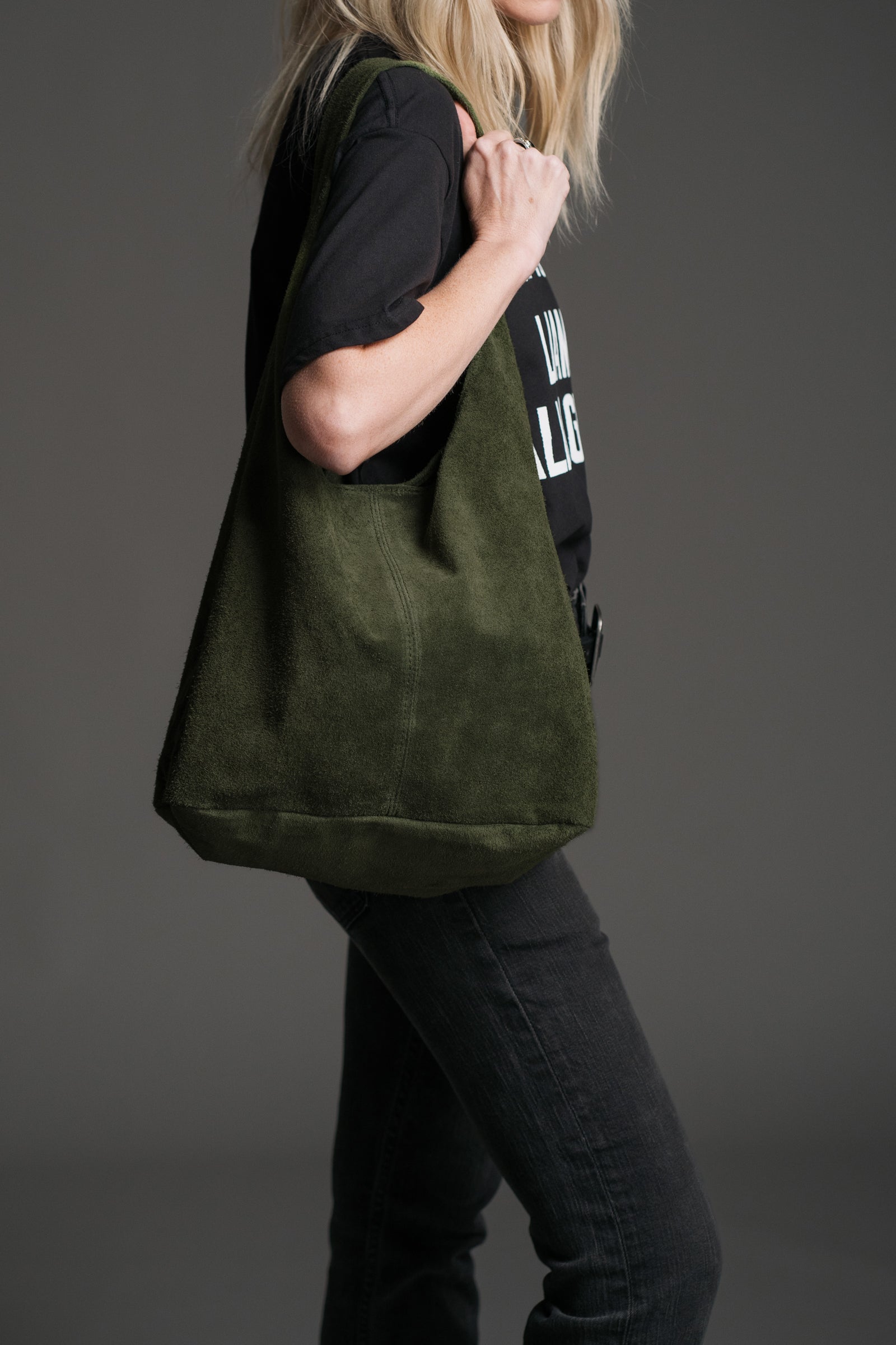 Olsen Khaki Genuine Suede Slouchy Bag styled over the shoulder with a black graphic tee and dark denim.