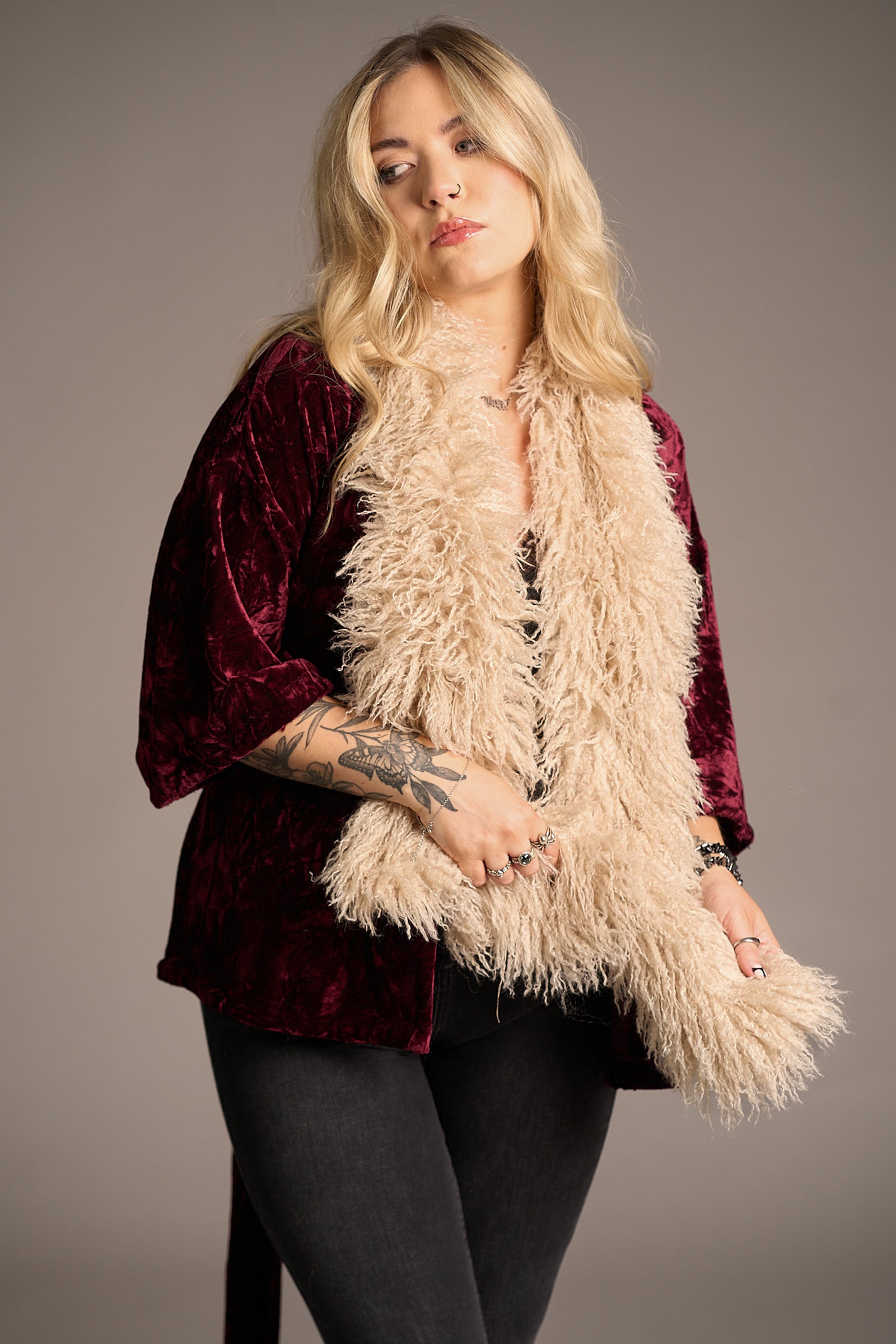 Erin wears cream Penny Lane Faux Mongolian Fur Scarf over burgundy velvet top