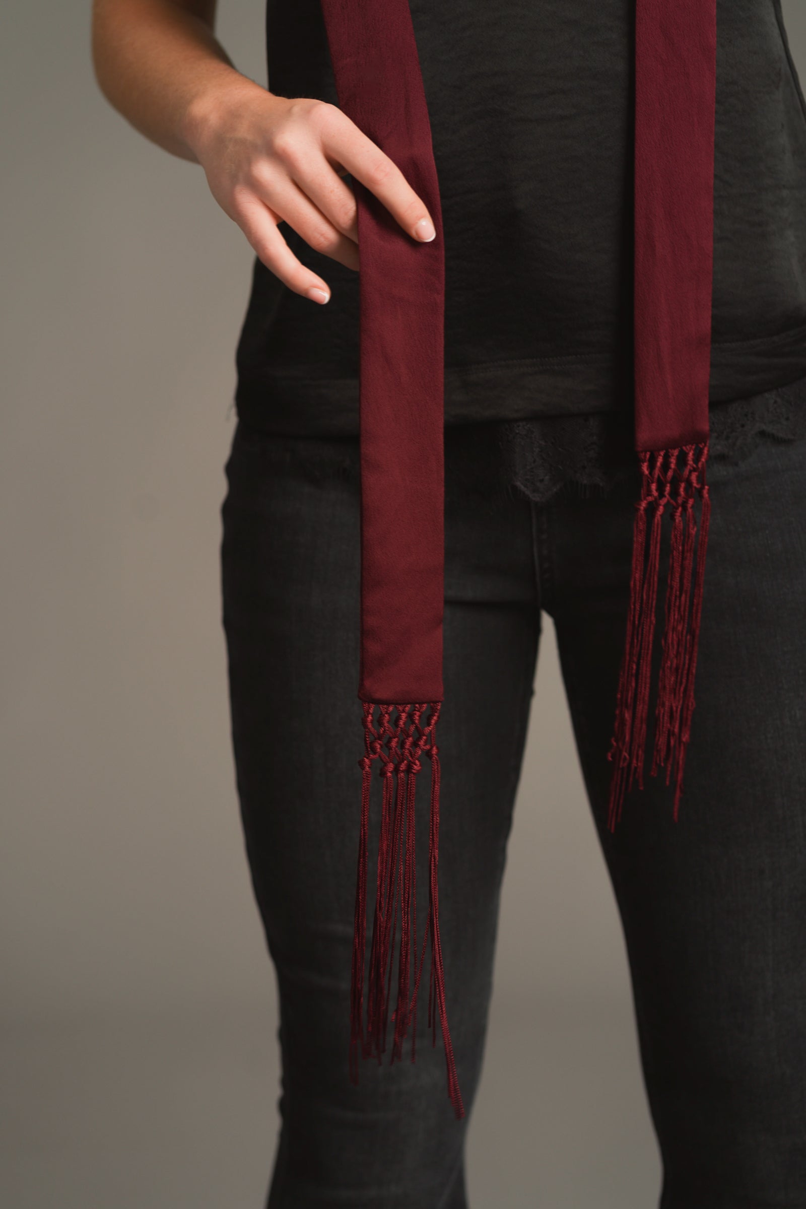 Close-up of plum skinny scarf showing hammered satin texture and fringe details
