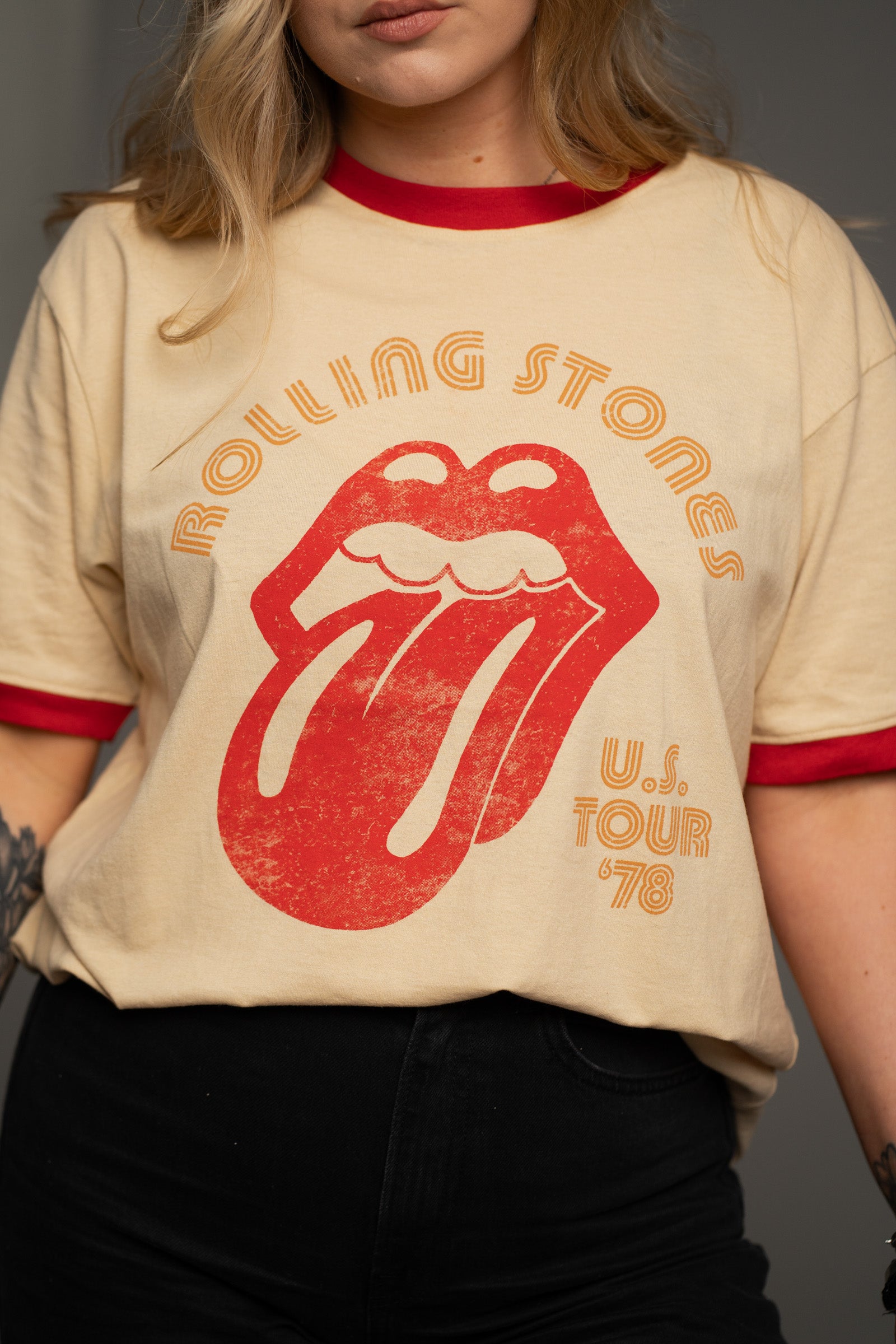Close-up of Rolling Stones retro tongue logo on natural ringer band tee from Little Lies