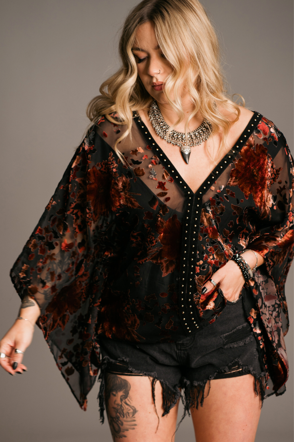 Model wearing the Rooms on fire floral Devore kimono top with studded details, a western style staple.