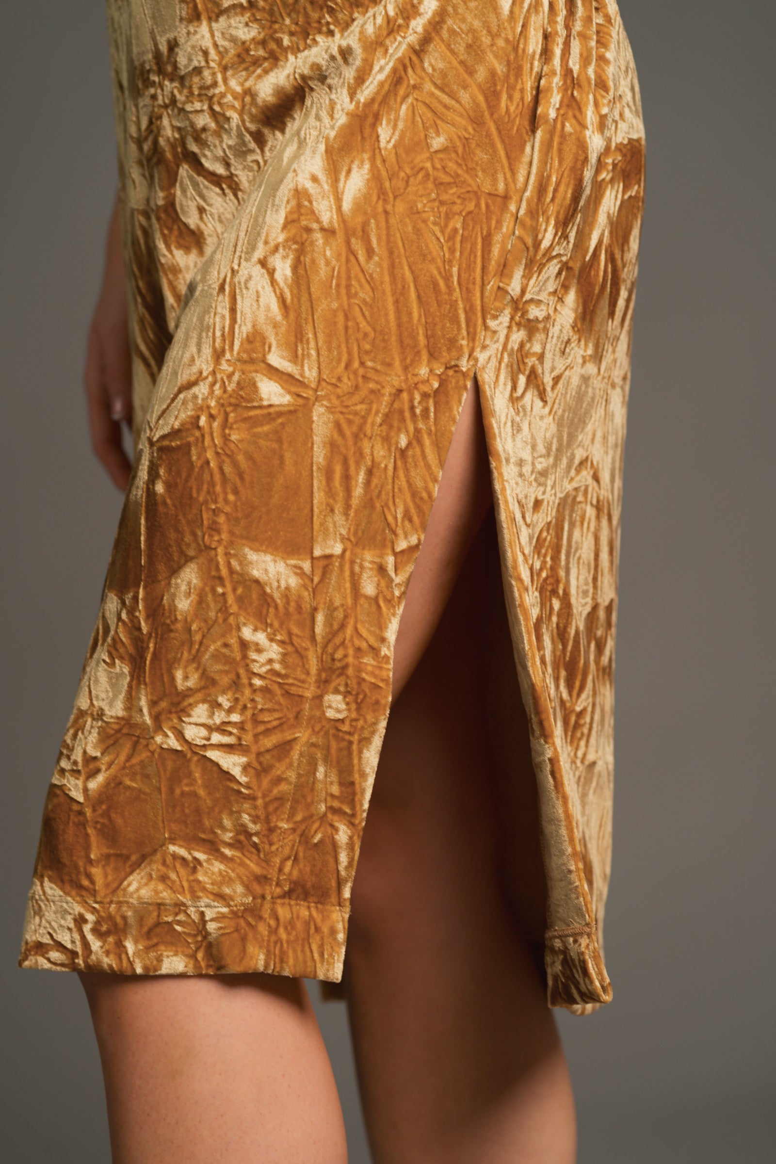 Close-up of side split in crushed velvet midi dress revealing buttery texture and movement